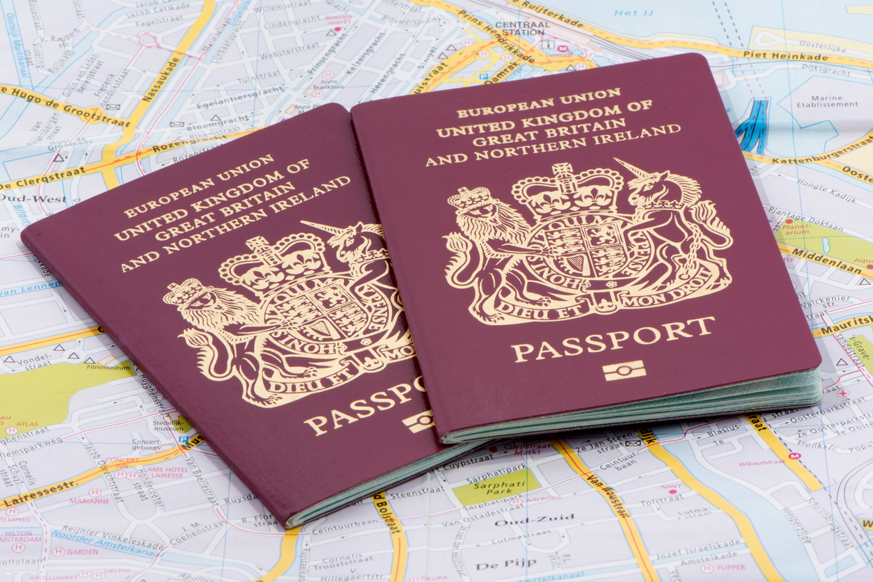 Londres, Reino Unido - 11 de diciembre de 2013;  Dos pasaportes biométricos del Reino Unido en una hoja de ruta europea tomada en un estudio.