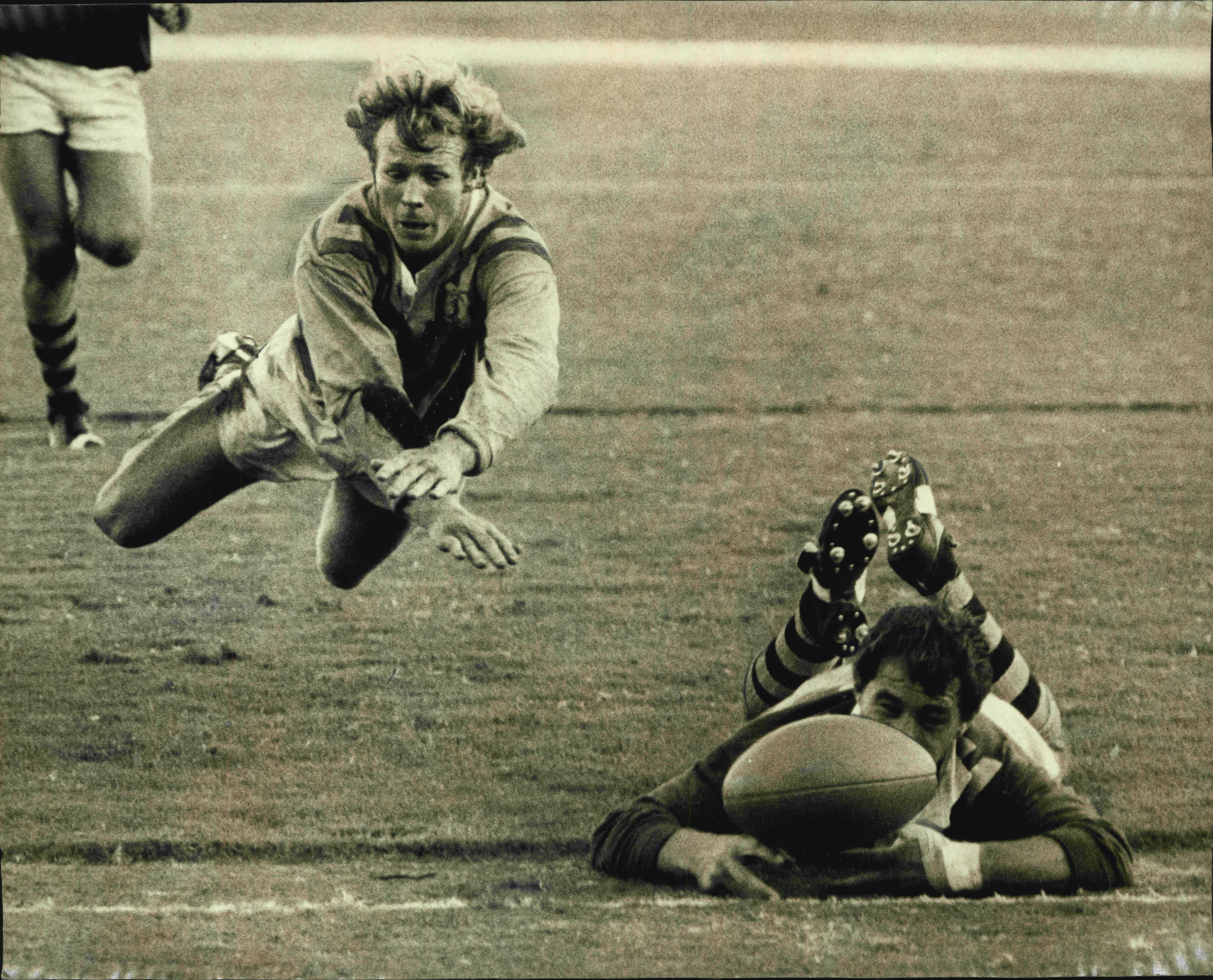 Sydney Firsts centre Bob Fulton looks aggrieved that his airborne attempted tackle is too late to stop Country half-back Brian Burke's disputed try in the Rugby League match at the SCG yesterday. May 19, 1973. (Photo by John Patrick O'Gready/Fairfax Media).