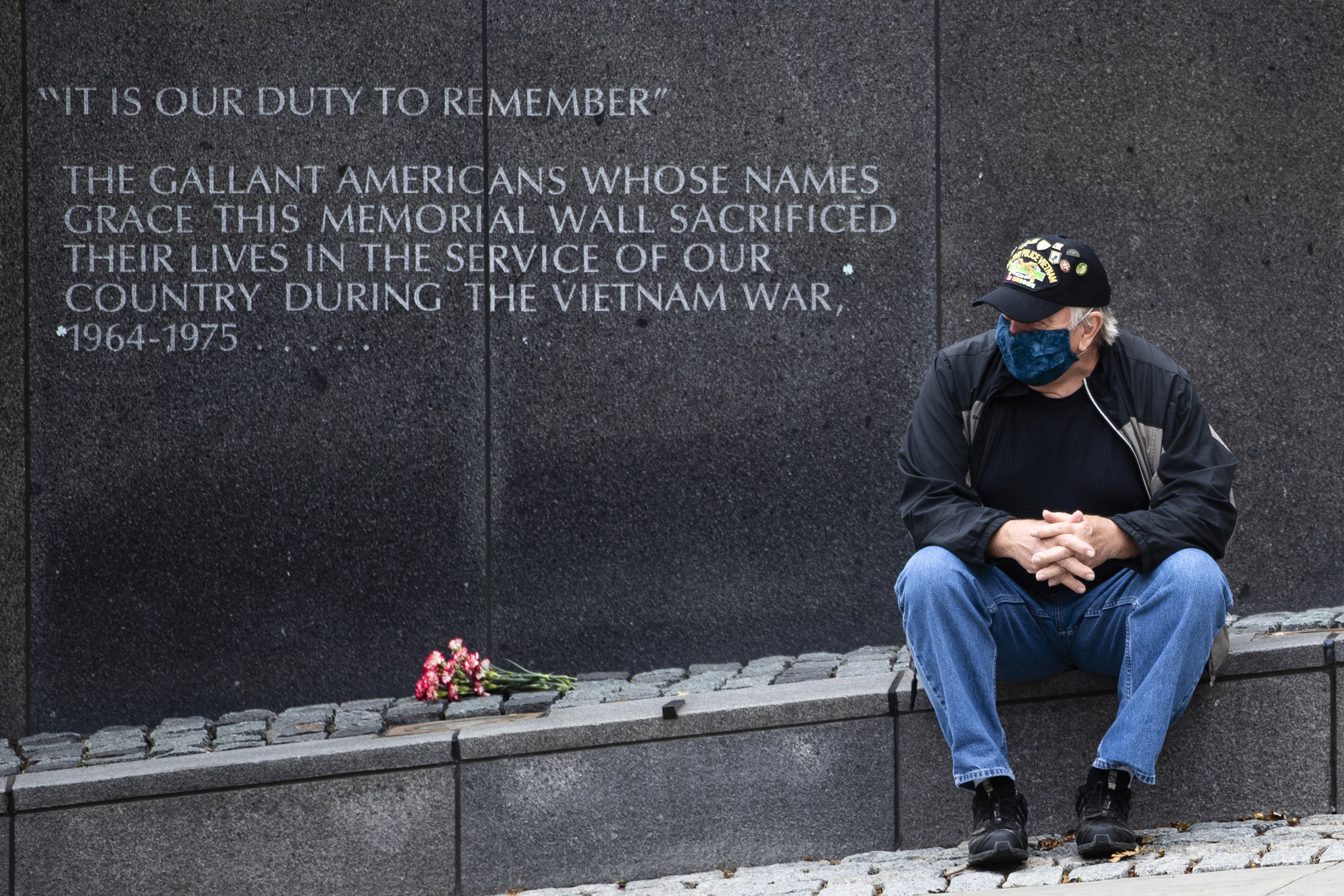 Vietnam Veteran Kitch Kichula, wearing a protective face mask as a precaution against the coronavirus, pays his respects at the at the Vietnam War Memorial, in Philadelphia, on Memorial Day