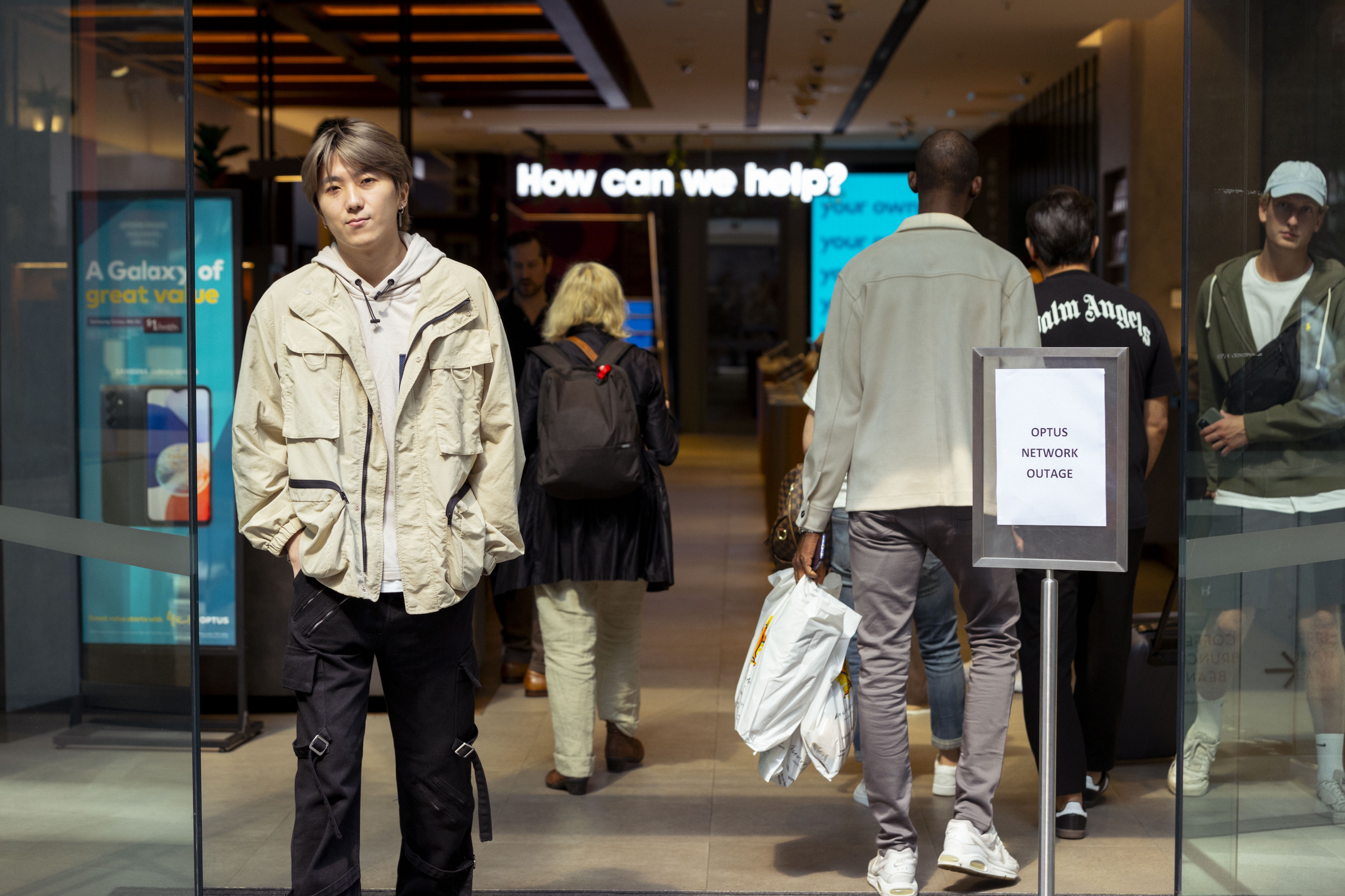 Customers line up outside an Optus shop fron