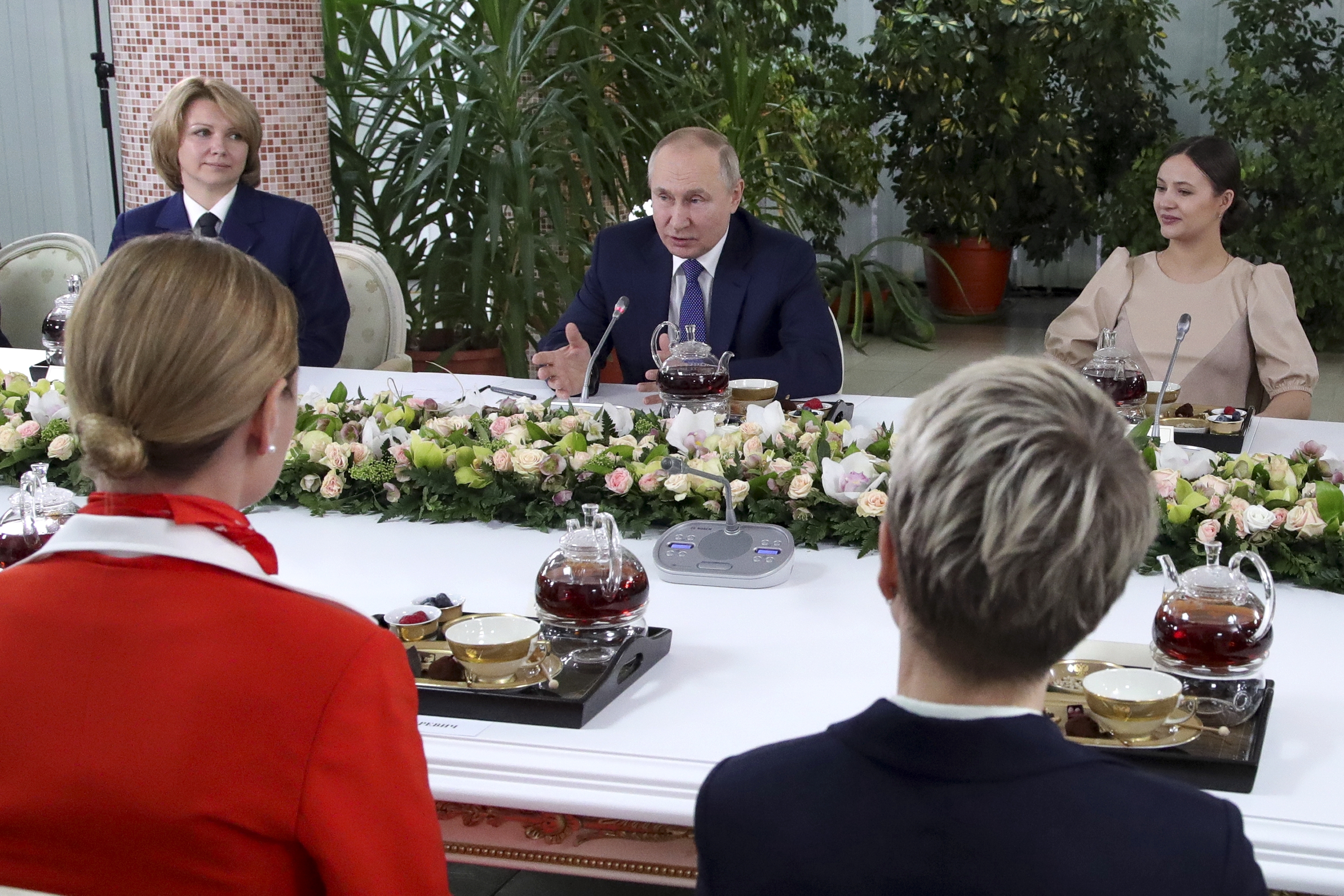 Russian President Vladimir Putin, centre, speaks to representatives of the flight crew of Russian airlines as he visits to Aeroflot Aviation School outside Moscow, Russia, Saturday, March 5, 2022 