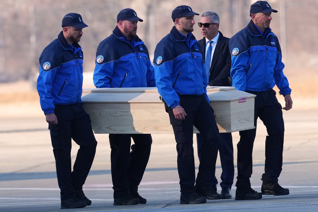 Police officers carry a coffin with the body of one of six Italians at the Military Airport in Sion, Swiss Alps, Switzerland