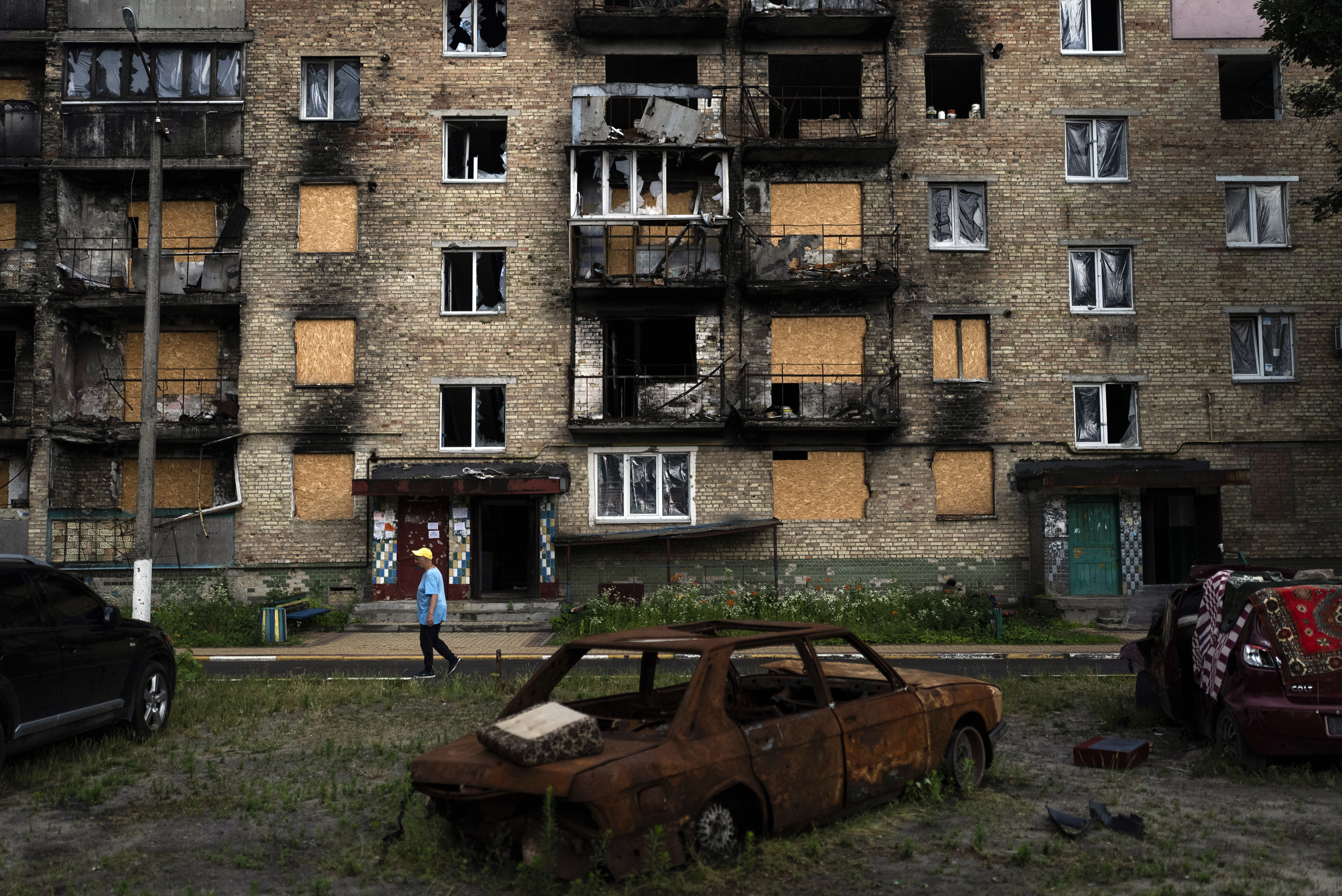 Un residente pasa junto a un edificio de apartamentos gravemente dañado por los ataques rusos en Irpin, Ucrania.