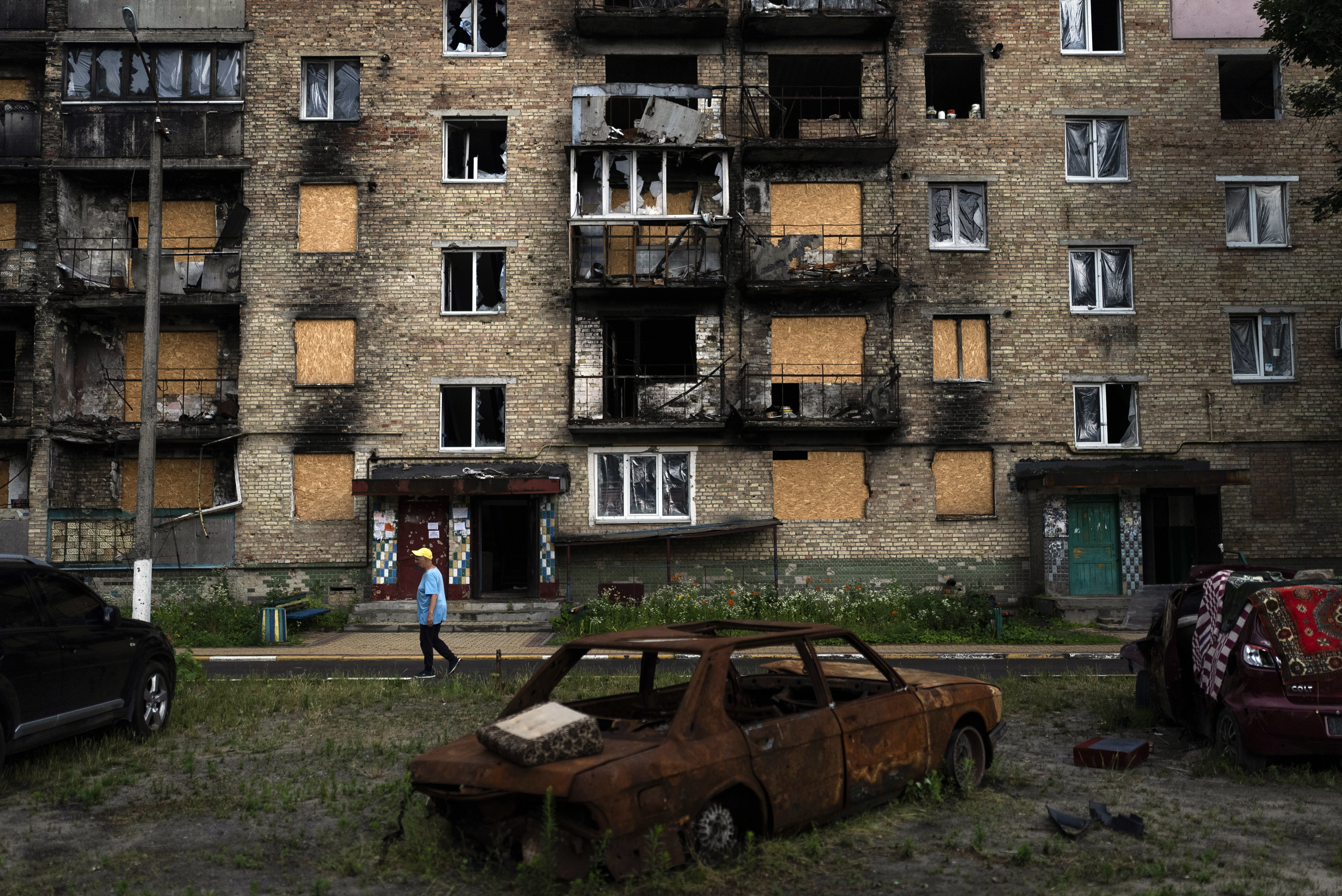 A resident walks past an apartment building heavily damaged in Russian attacks in Irpin, Ukraine.