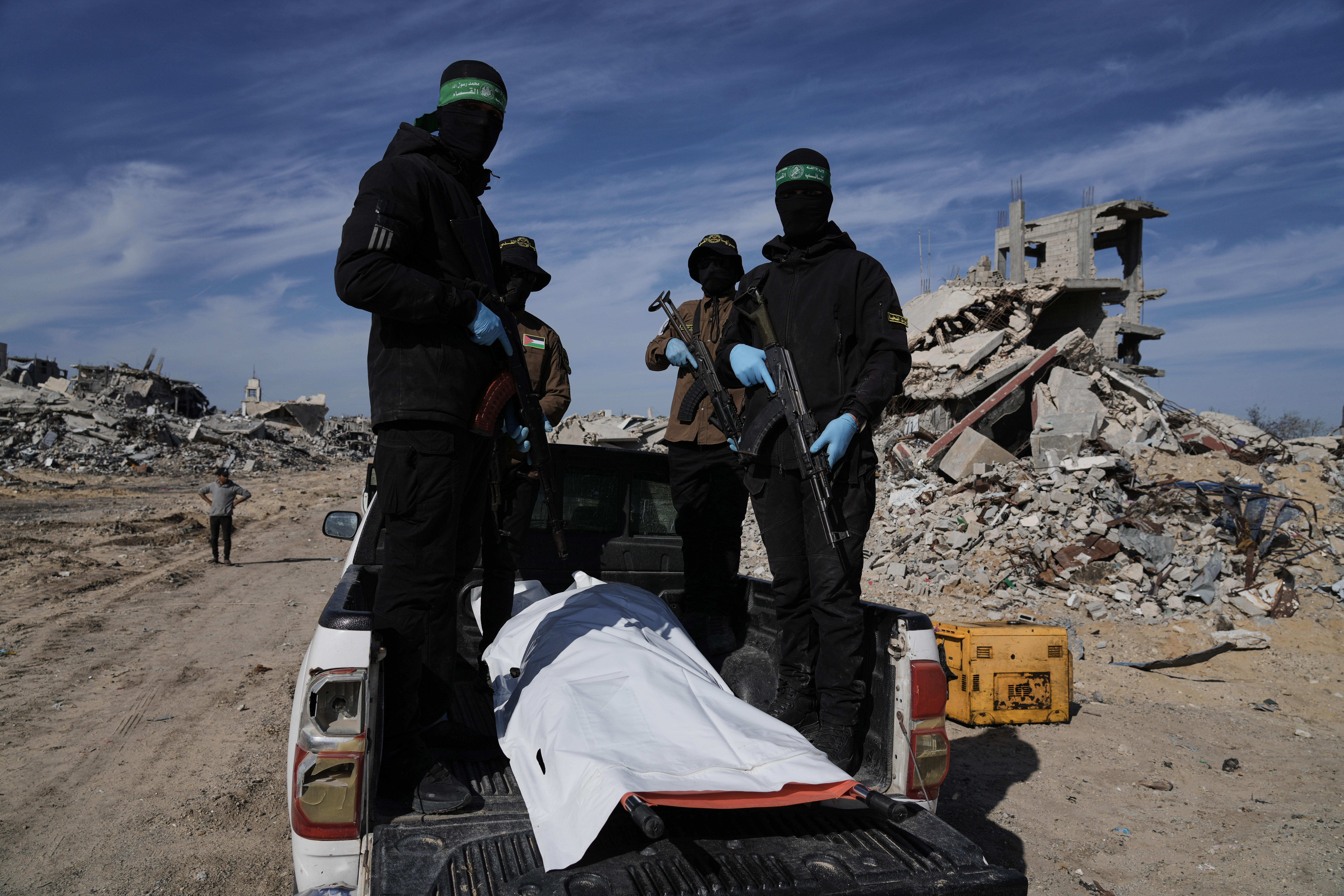 Islamic Jihad and Hamas militants carry a white body bag that is believed to be the remains of a deceased hostage, in the town of Beit Lahiya in northern Gaza Strip, Wednesday, Dec. 3, 2025. (AP Photo/Jehad Alshrafi).