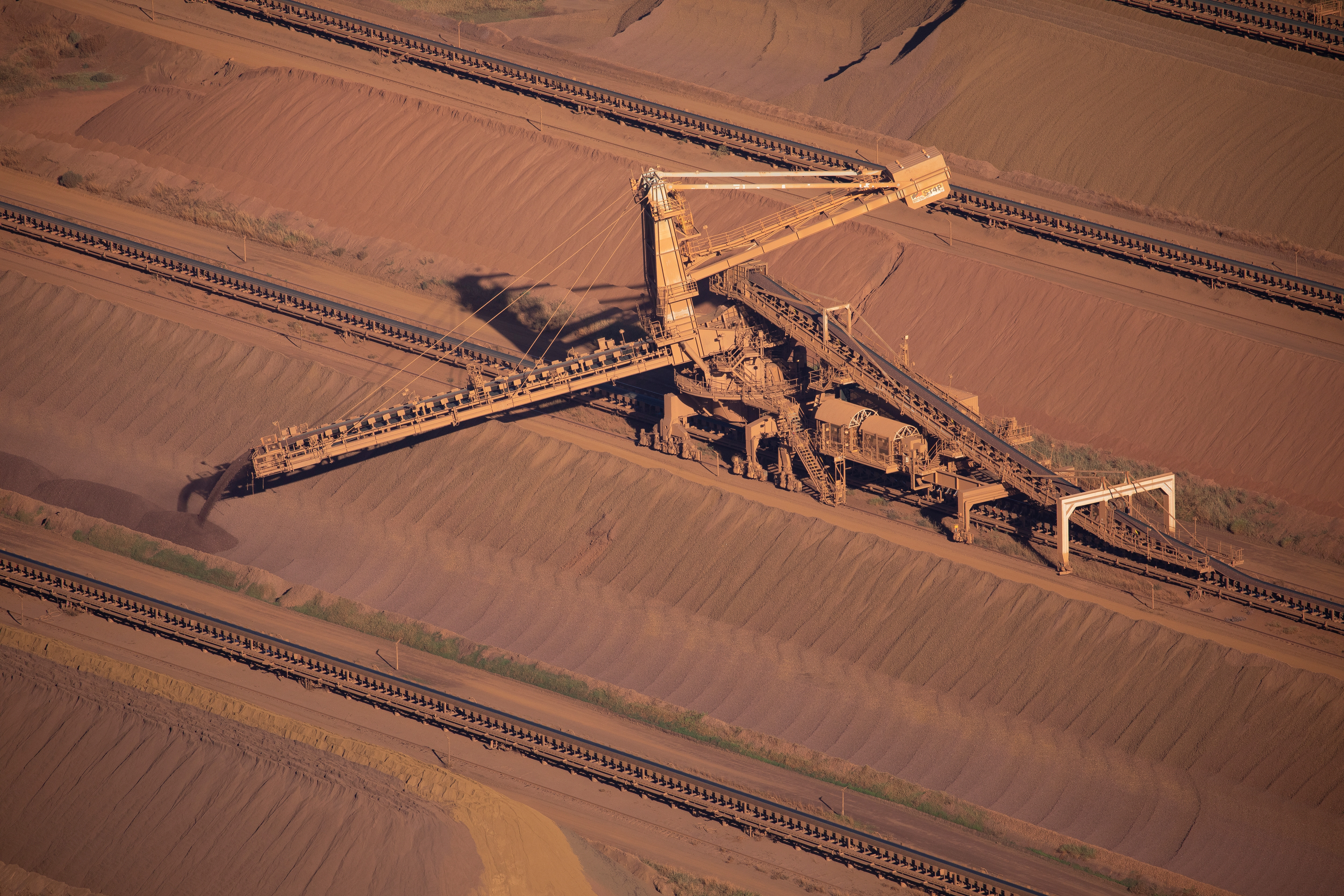 An iron ore stacker feeds stockpiles at Rio Tinto iron ore mine site in the Pilbara region of Western Australia.