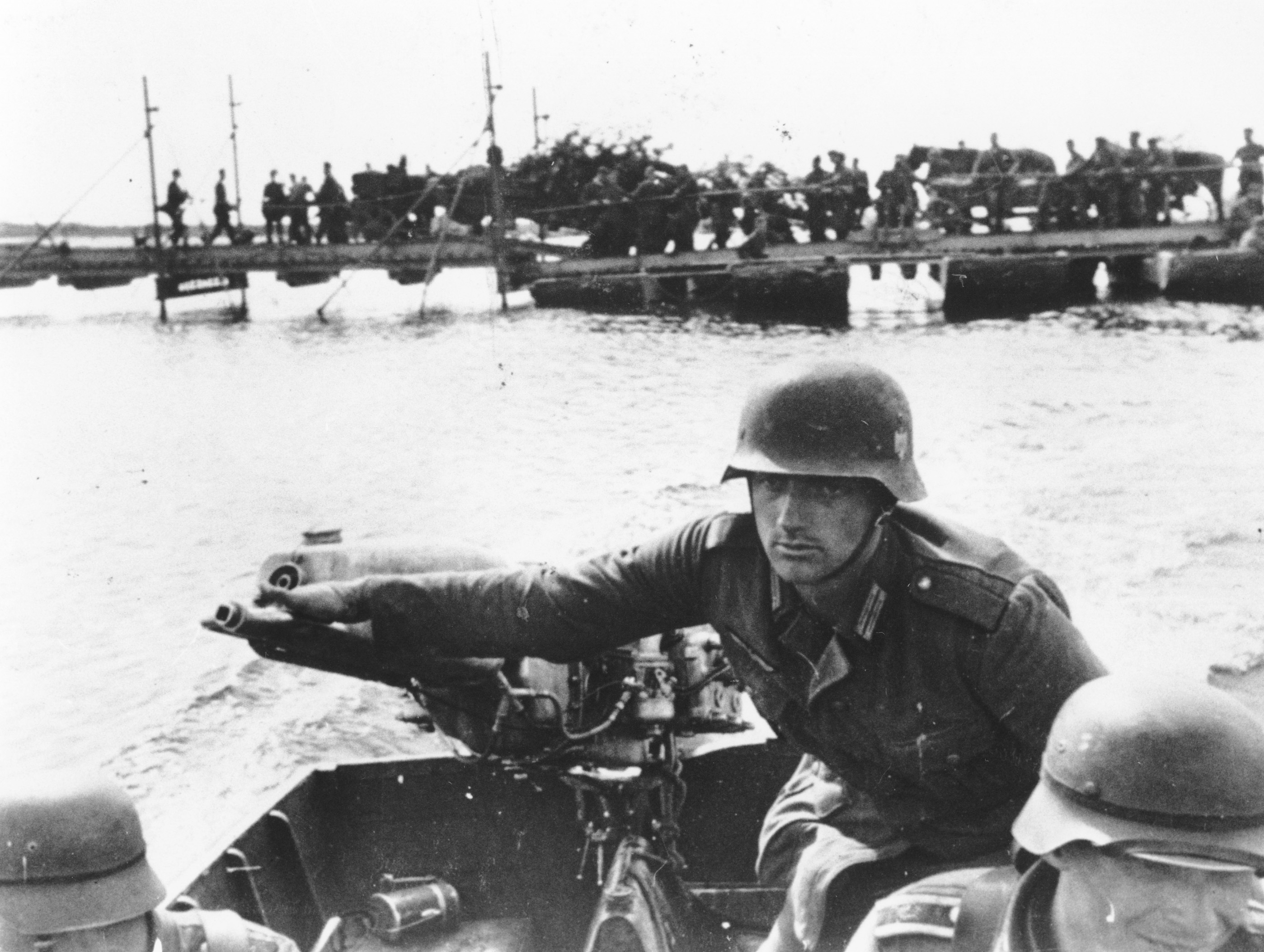 As the German invasion of the Ukraine continues, a German soldier is seen as he operates the outboard engine of a motorboat while crossing the Dnieper river, in September 1941. Standing in the background are troops and military vehicles awaiting their turn. AP Photo)