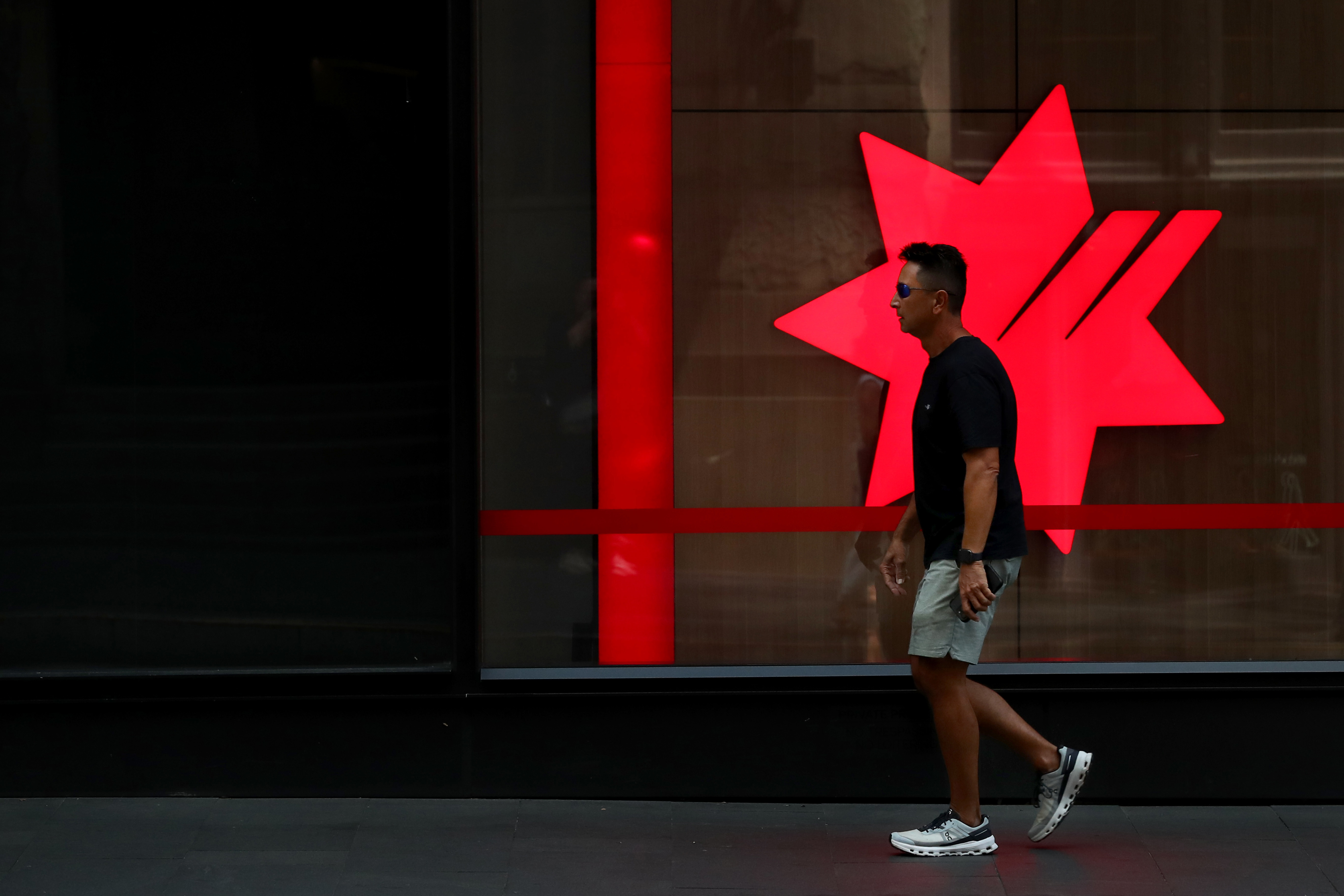 SYDNEY, AUSTRALIA - FEBRUARY 18: A pedestrian moves past a National Australia Bank Ltd. (NAB) central business district branch  on February 18, 2025 in Sydney, Australia. The Reserve Bank of Australia (RBA) is set to announce its monetary policy decision on February 18, 2025, with many experts predicting a rate cut due to easing inflation and economic conditions. This anticipated cut aims to provide relief to mortgage holders and stimulate economic activity amid concerns about weak household con
