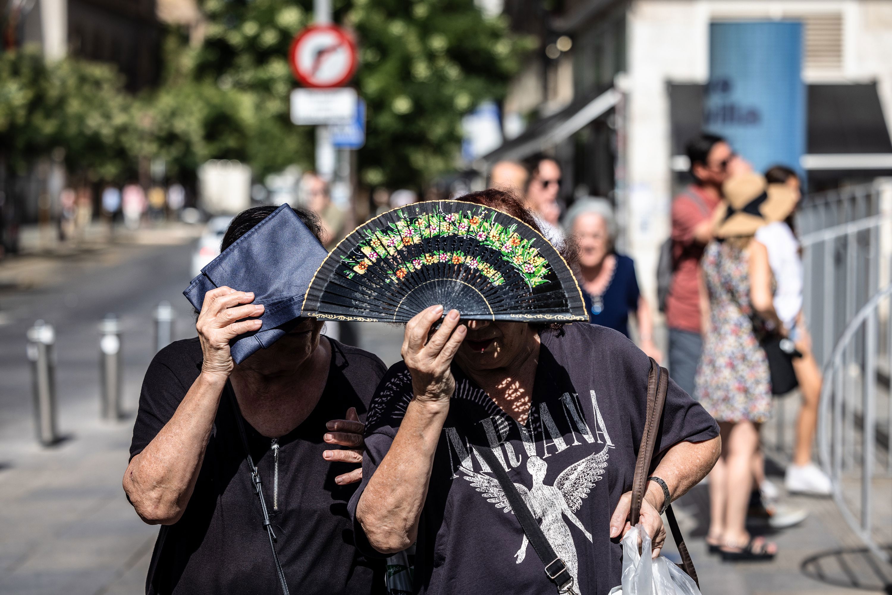 People shield themselves from the sun during high temperatures in Seville, Spain, on Thursday.