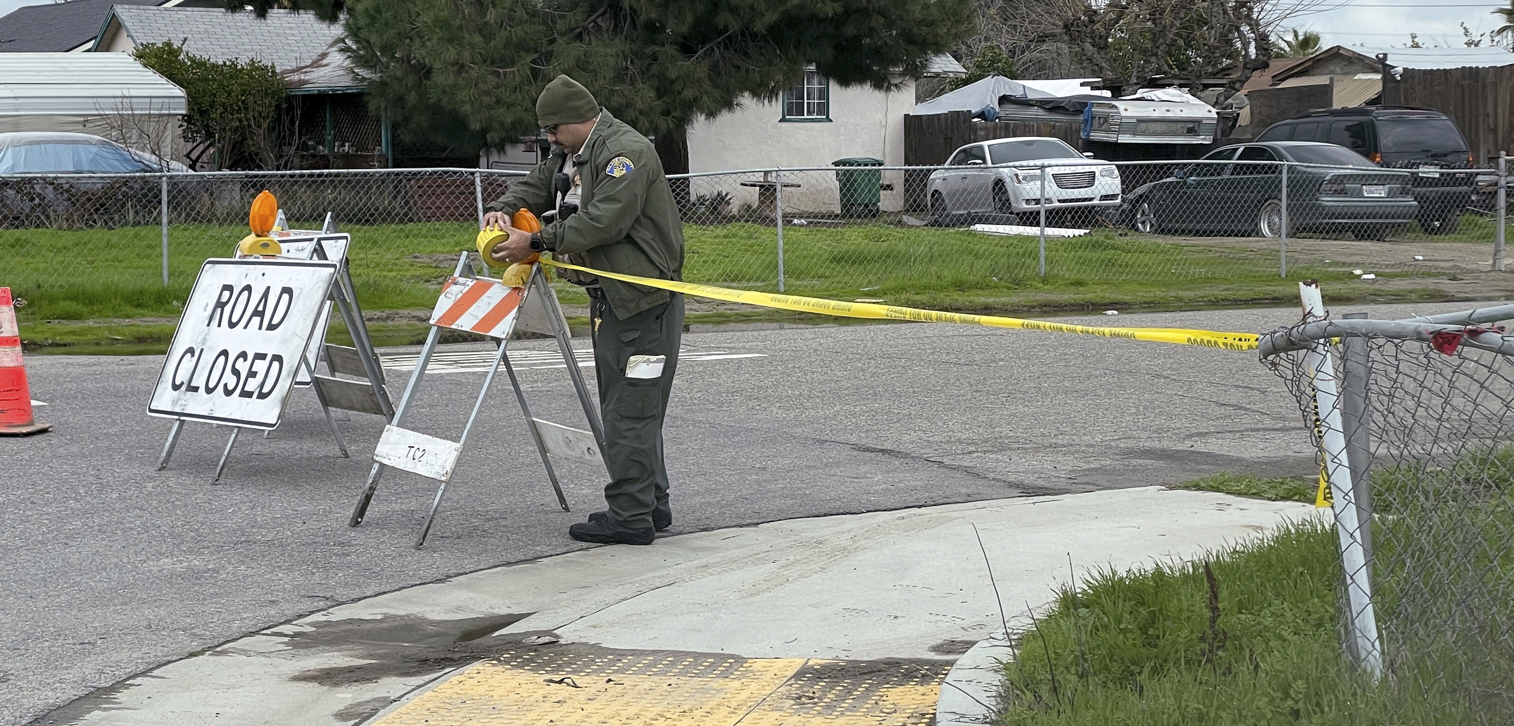 A Tulare County Sheriff's Deputy cordons off a road, Tuesday, Jan. 17, 2023 as detectives continues to investigate a shooting that left six people dead early Monday morning in Goshen California.