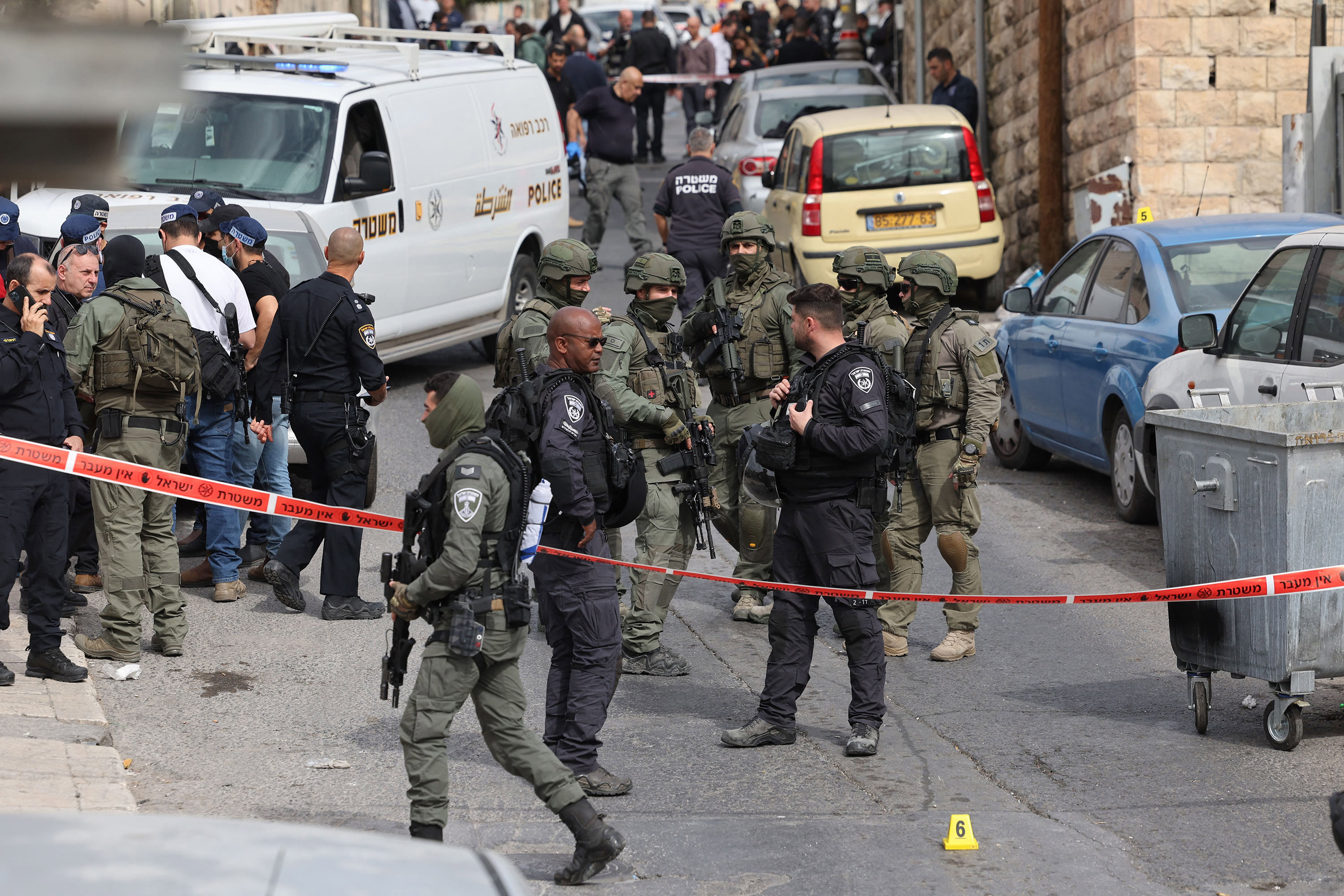 Israeli security forces and emergency service personnel gather at a cordoned-off area in Jerusalem's predominantly Arab neighbourhood of Silwan, where an assailant reportedly shot and wounded two people, on January 28, 2023.