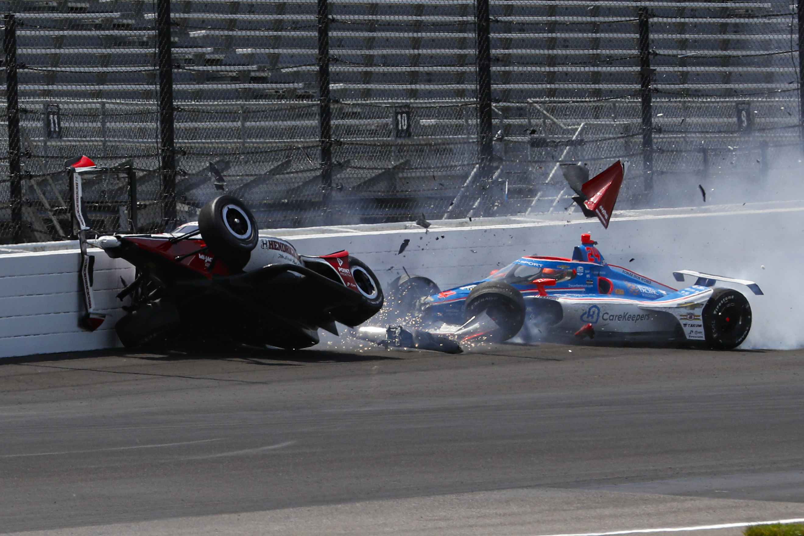 Katherine Legge (left) and Stefan Wilson crash in turn one at the Indianapolis 500 during practice.