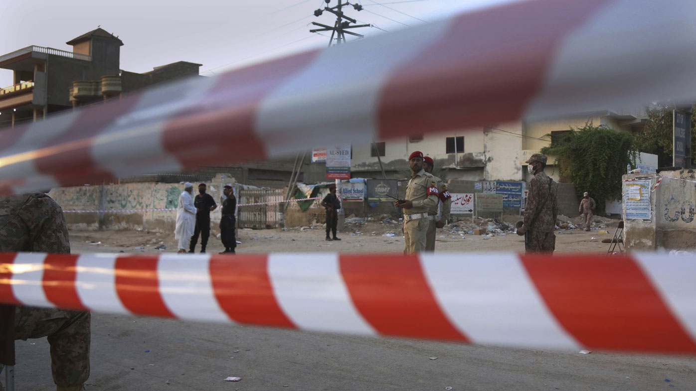Pakistan army soldiers and police commandos stand guard while they cordon off a street leading to the site of a plane crash, in Karachi, Pakistan, Saturday, May 23, 2020.