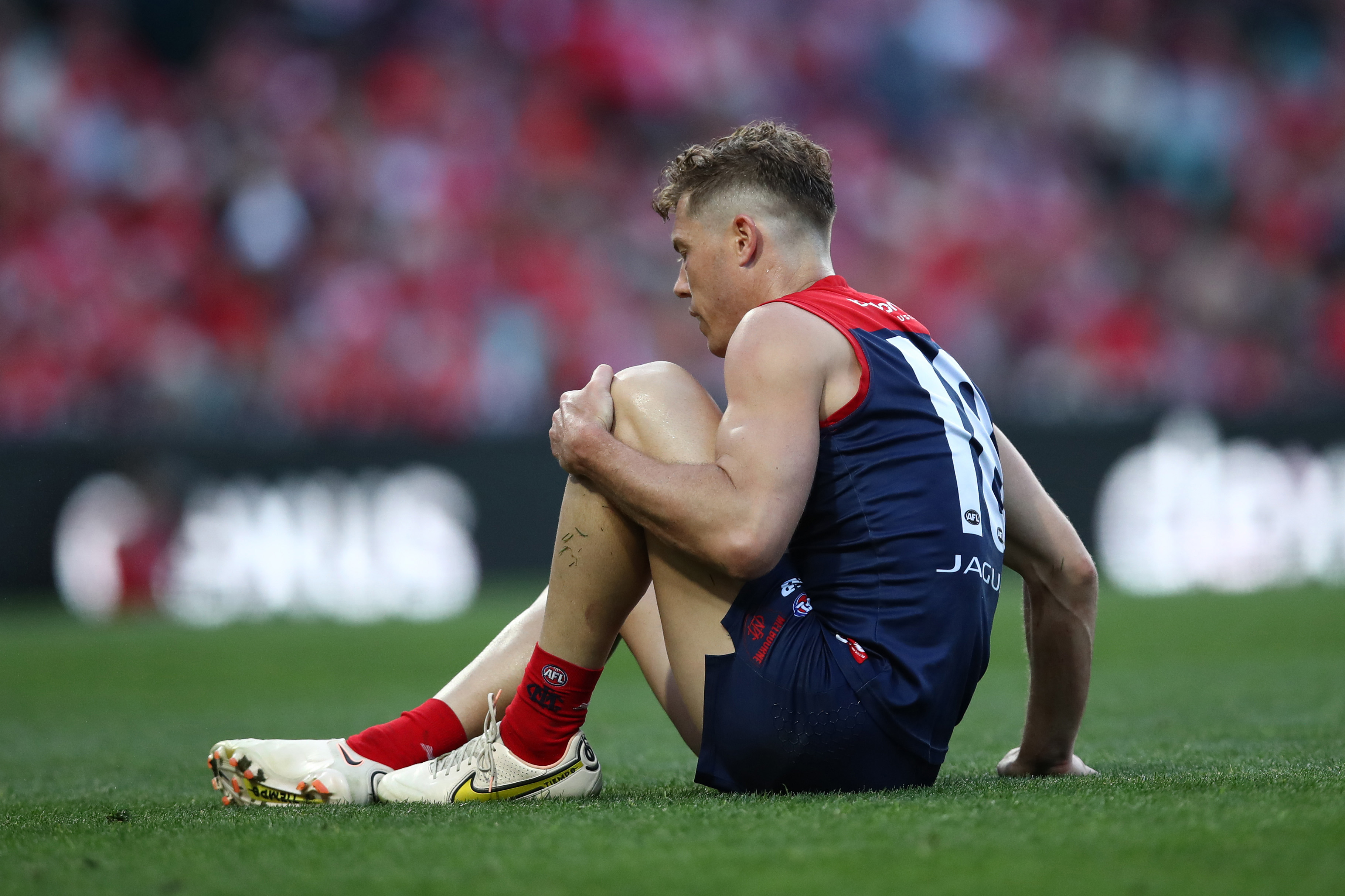 SYDNEY, AUSTRALIA - AUGUST 27: Jake Melksham of the Demons holds his knee during the round 24 AFL match between Sydney Swans and Melbourne Demons at Sydney Cricket Ground on August 27, 2023 in Sydney, Australia. (Photo by Jason McCawley/AFL Photos/via Getty Images )