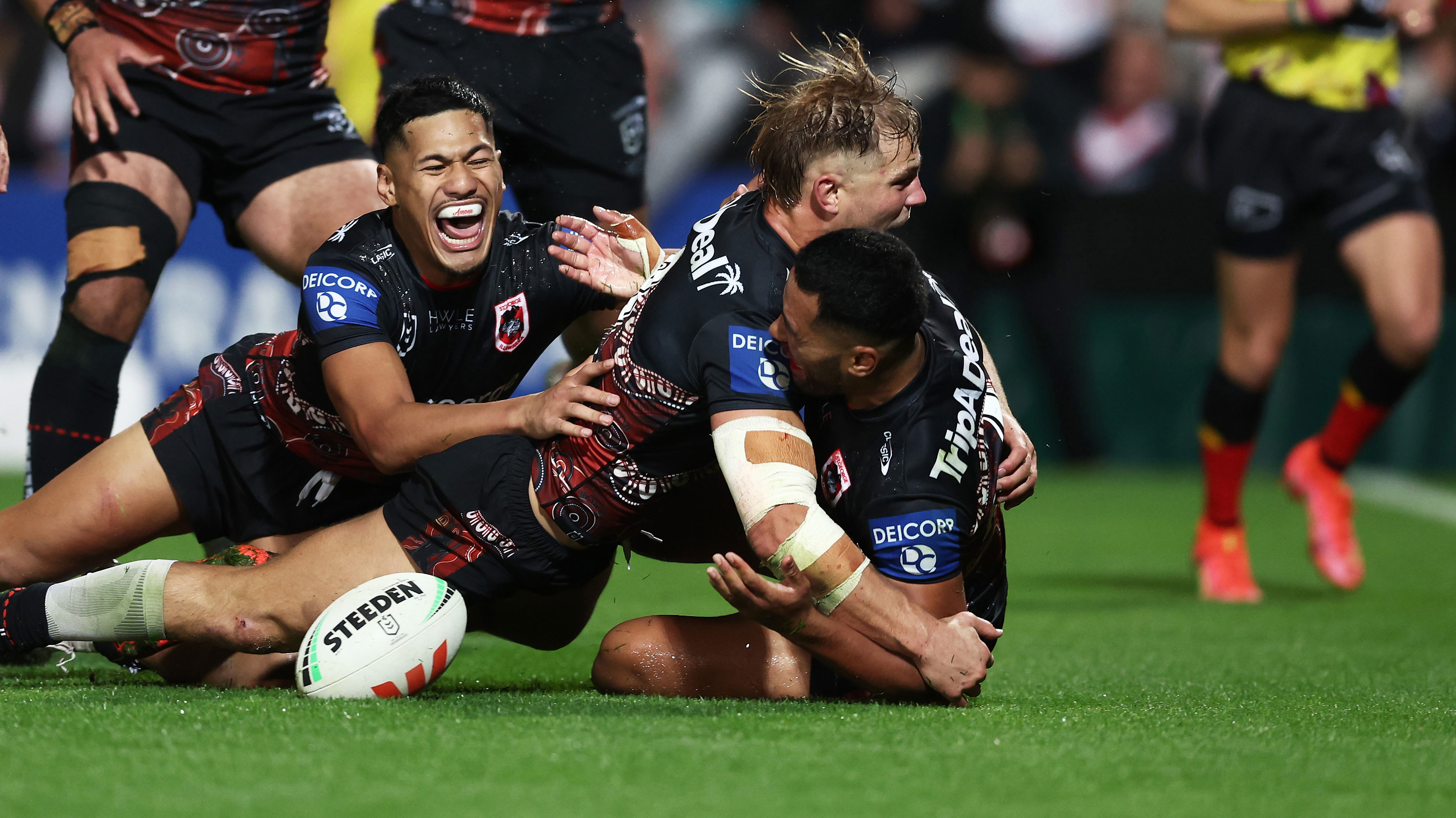 Jack de Belin jumps on Mathew Feagai as the Dragons celebrate the match winning try against the Roosters.