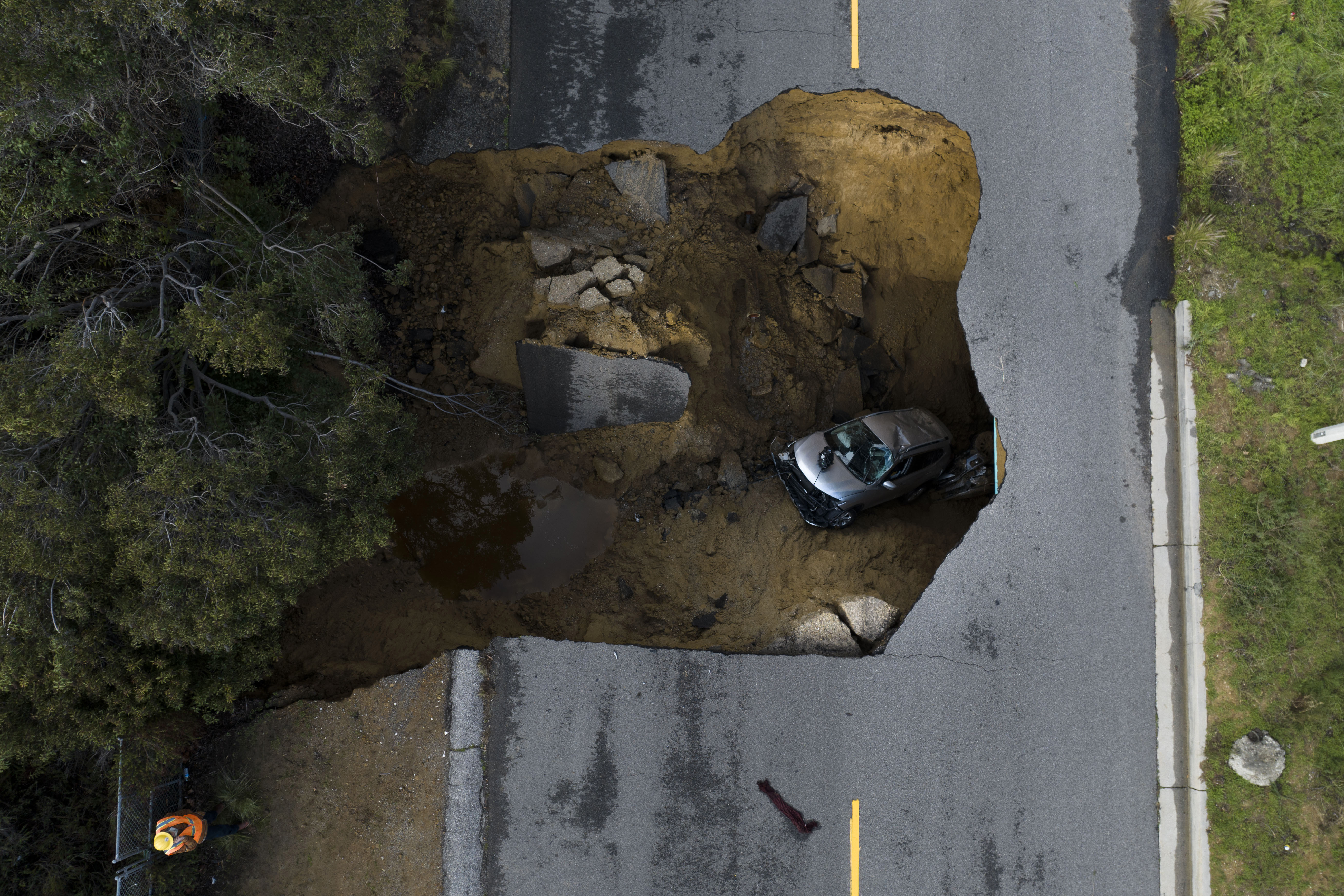 A vehicle is stuck in a sinkhole in the Chatsworth section of Los Angeles taken from a drone, Tuesday, Jan. 10, 2023.  