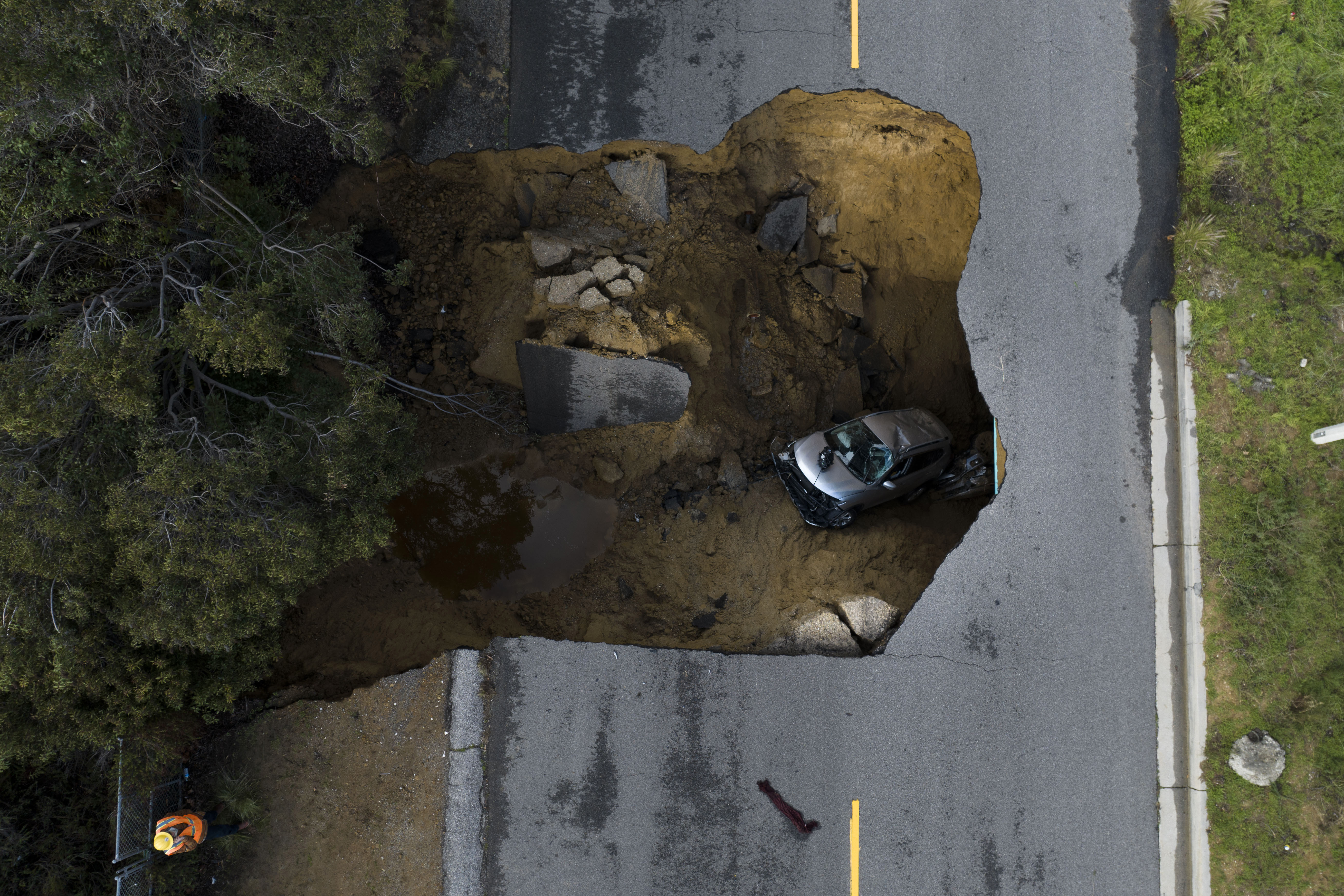 A vehicle is stuck in a sinkhole in the Chatsworth section of Los Angeles taken from a drone, Tuesday, Jan. 10, 2023.