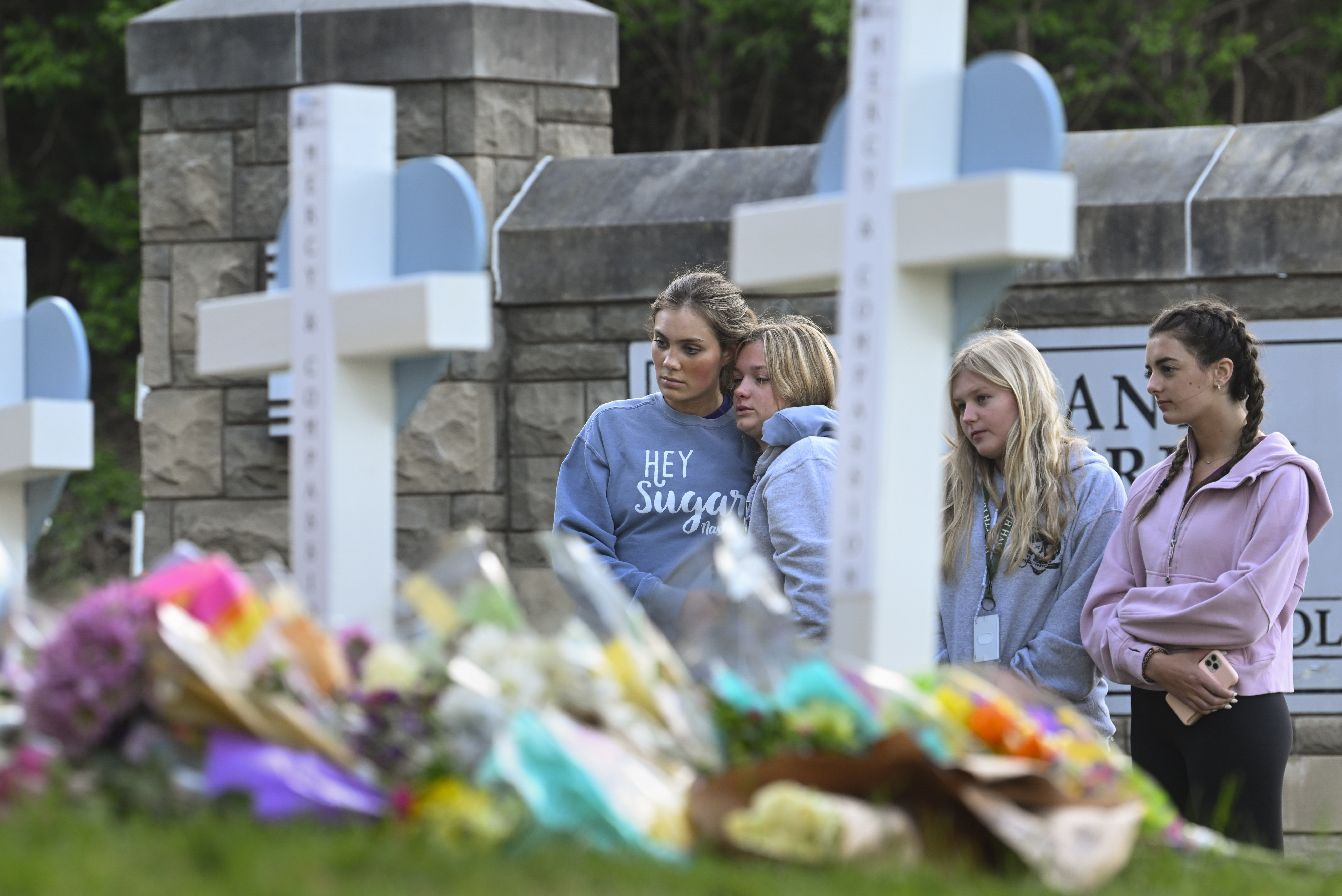 Los estudiantes de una escuela cercana presentan sus respetos en un monumento a las personas que fueron asesinadas, en la entrada de la Escuela Covenant, el martes 28 de marzo de 2023, en Nashville, Tennessee.