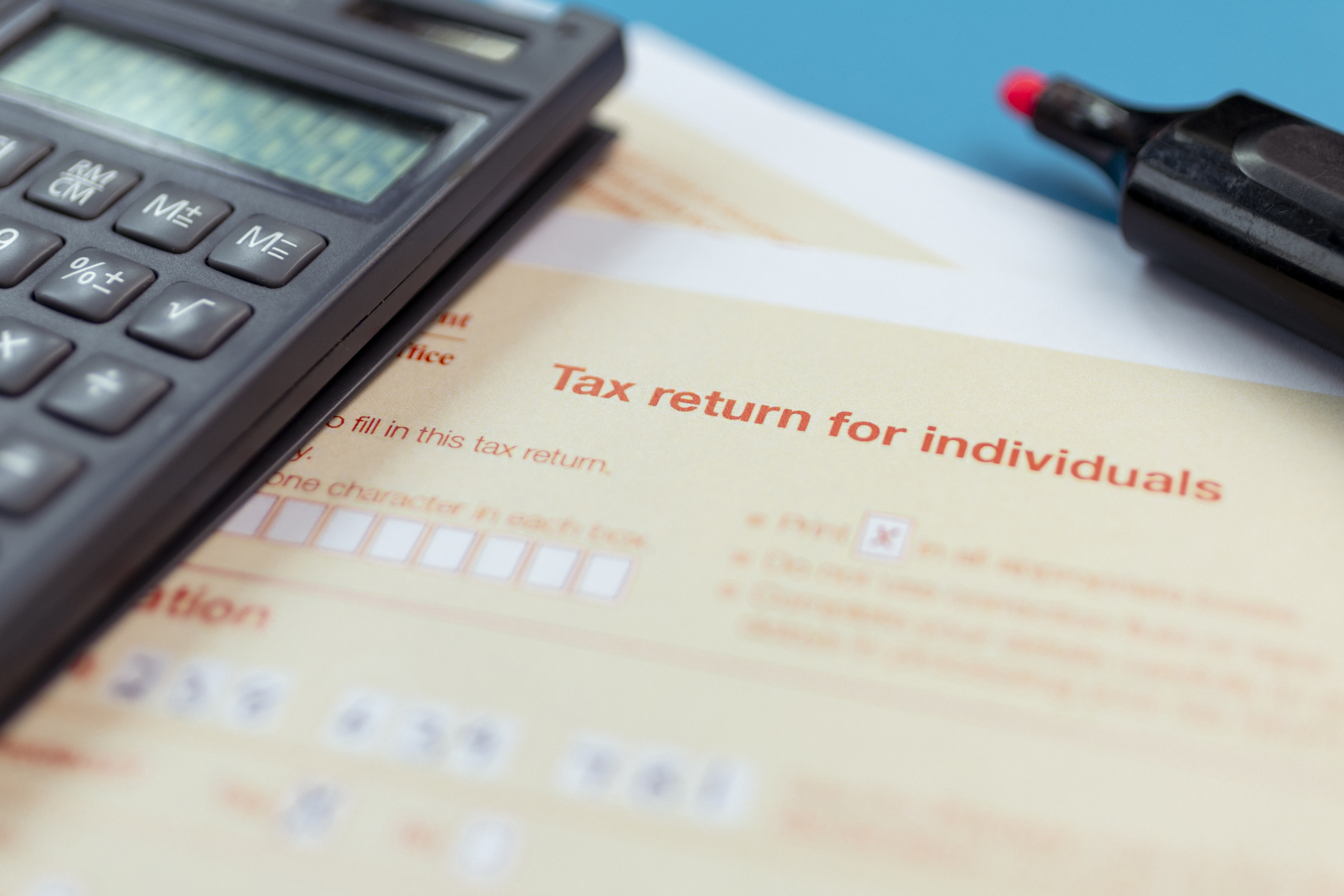 Generic picture of someone filling out a tax return.