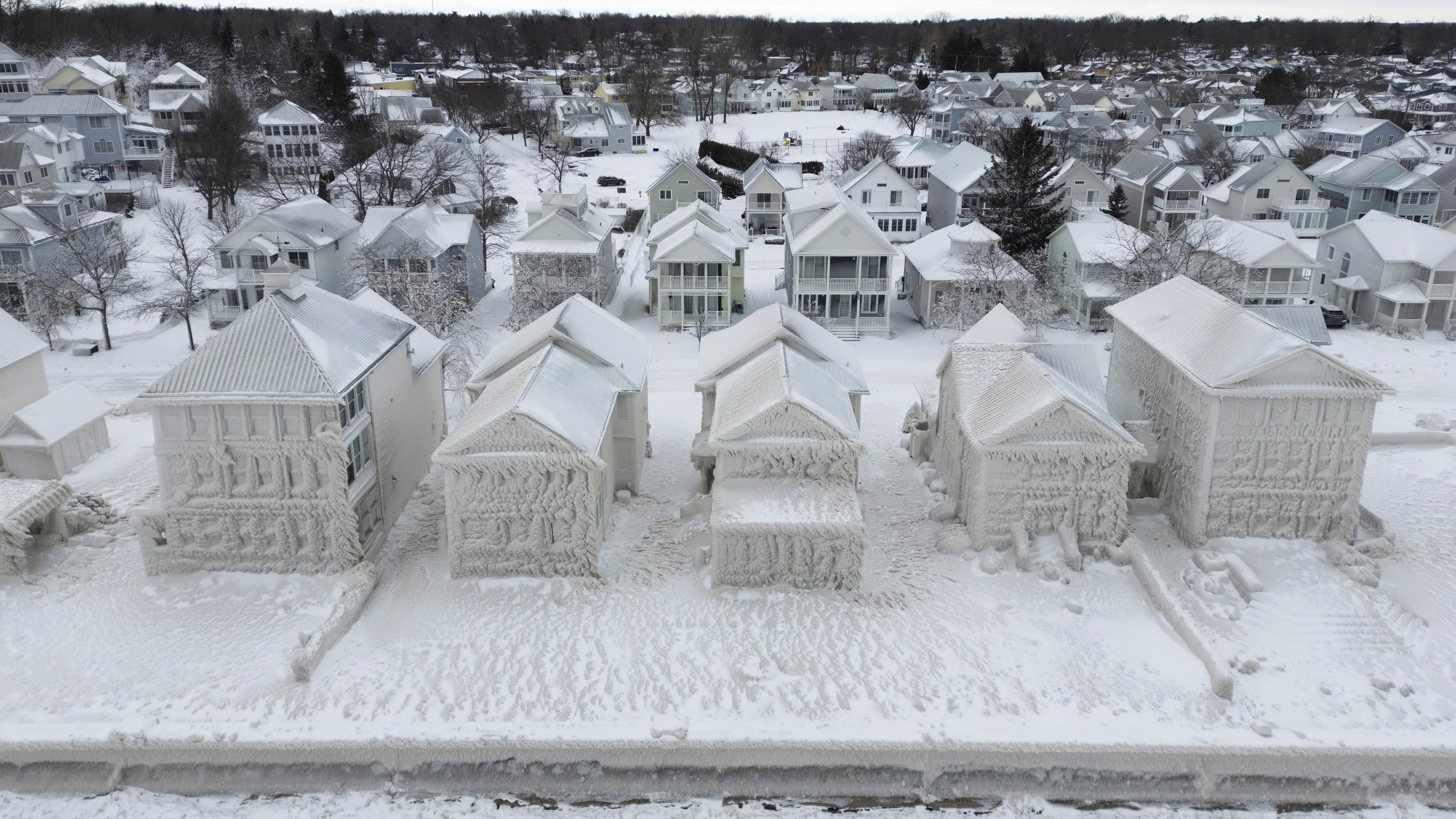 In this image taken by drone, houses along the shores of Lake Erie, near Fort Erie, Ontario, remain covered in ice following a winter storm that swept through much of Ontario. 