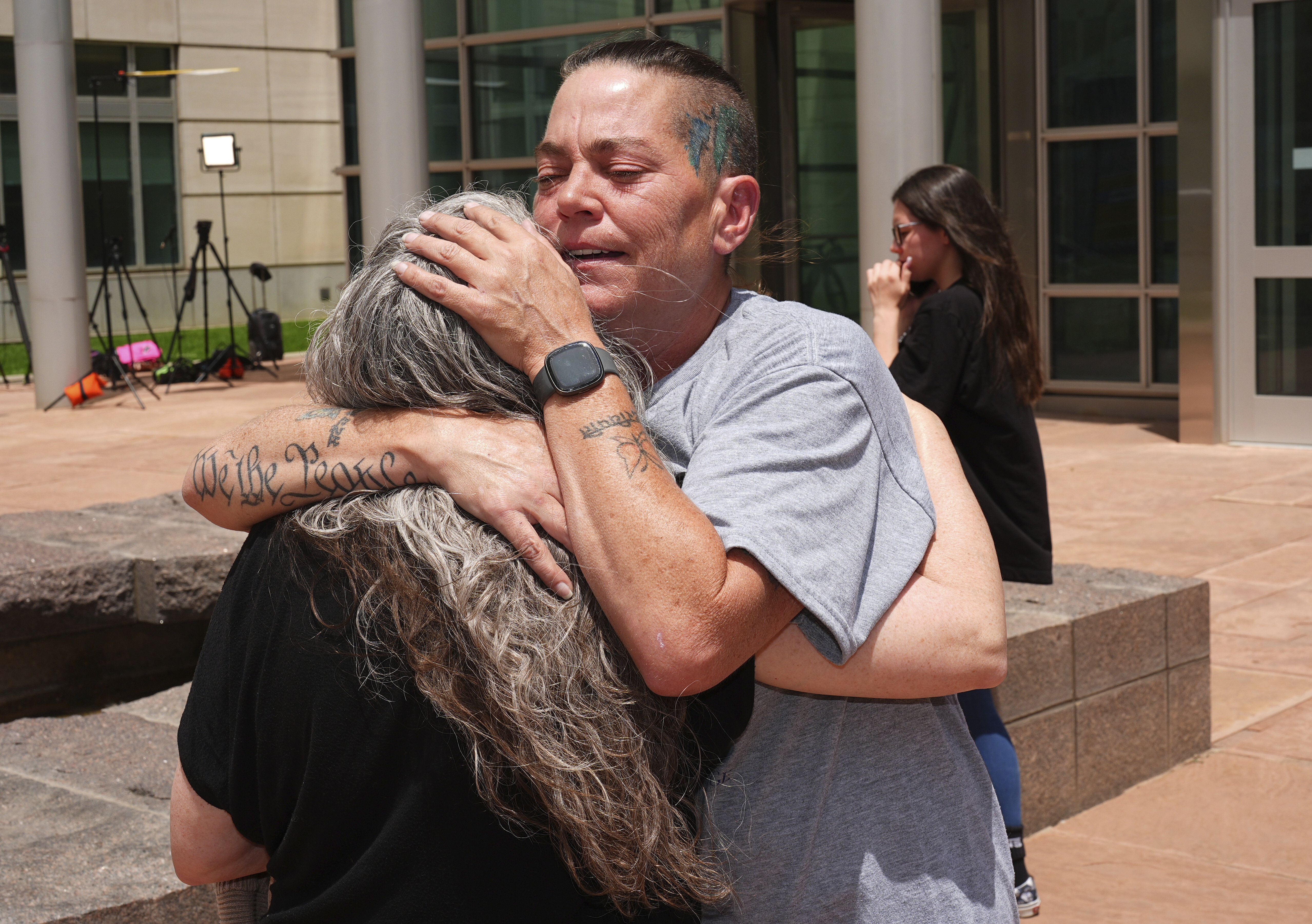 Crystina Page, right, hugs Beth Mosley, who both had retained the services of a Colorado funeral home owner who stashed nearly 190 decomposing bodies, after the owner was sentenced to 20 years prison on federal fraud charges, Friday, June 27, 2025, in Denver. (AP Photo/David Zalubowski)