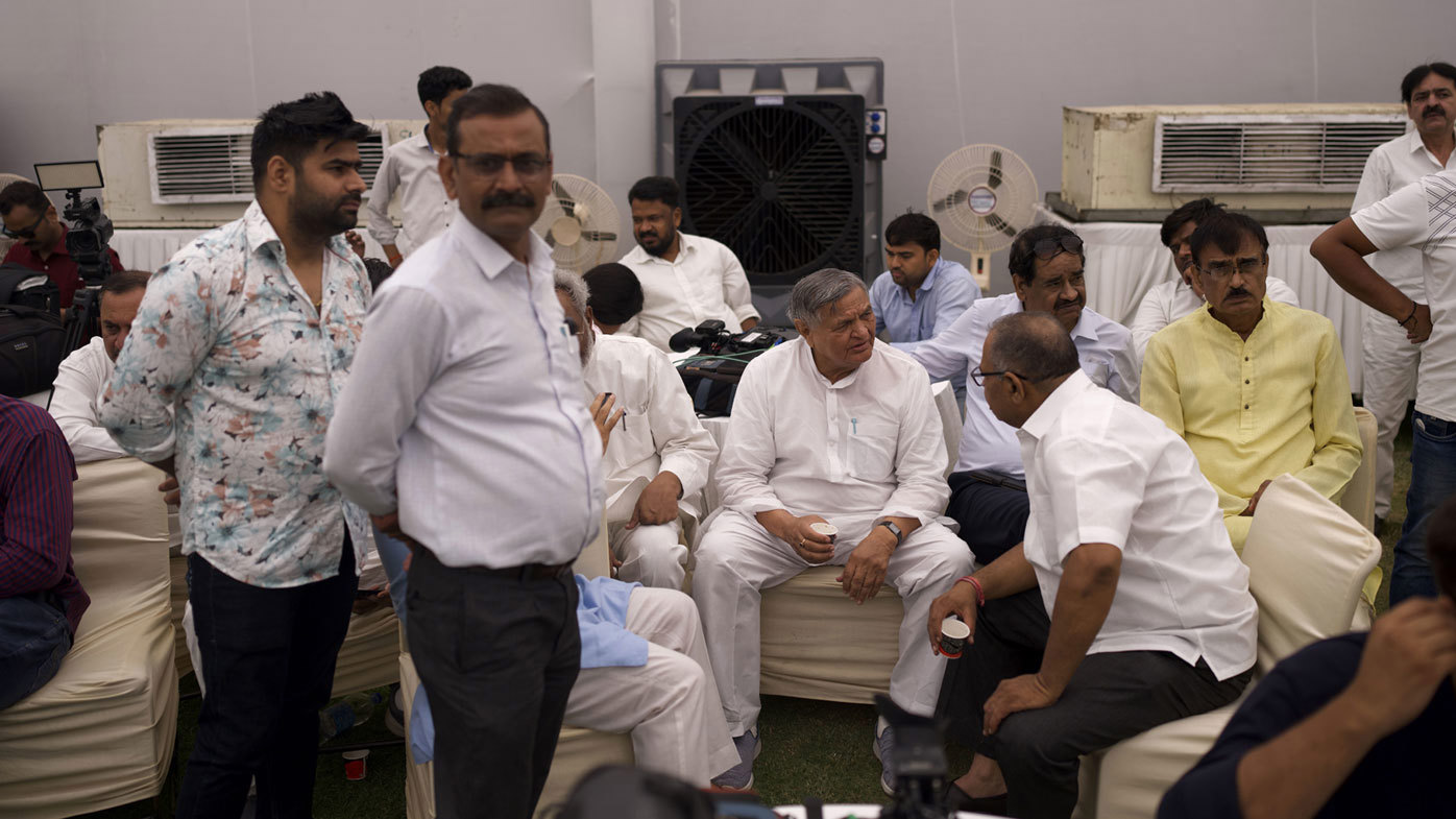 India election 2024 - People rest in front of water coolers and fans set up inside a tent at the Congress party headquarters in New Delhi, India.