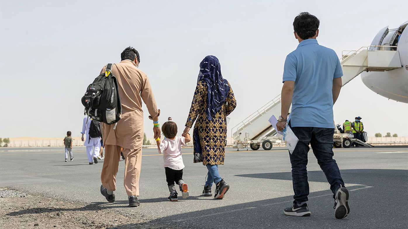 A family on the tarmac at Kabul Airport prepares to board a flight taking them to Australia.