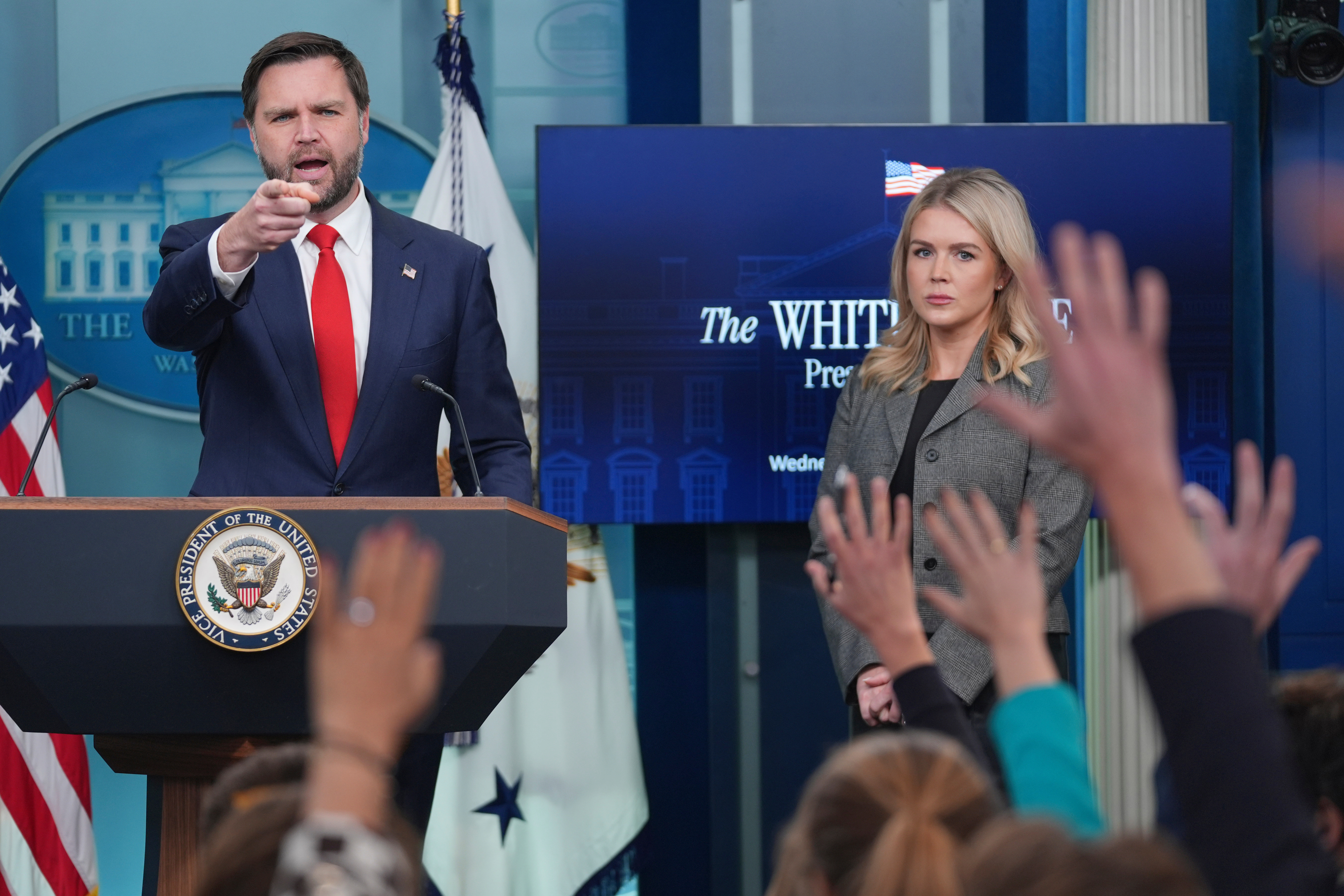 Vice President JD Vance, gestures as he stands with White House press secretary Karoline Leavitt, right, while speaking with reporters in the James Brady Press Briefing Room at the White House, Wednesday, Oct. 1, 2025, in Washington. (AP Photo/Evan Vucci)