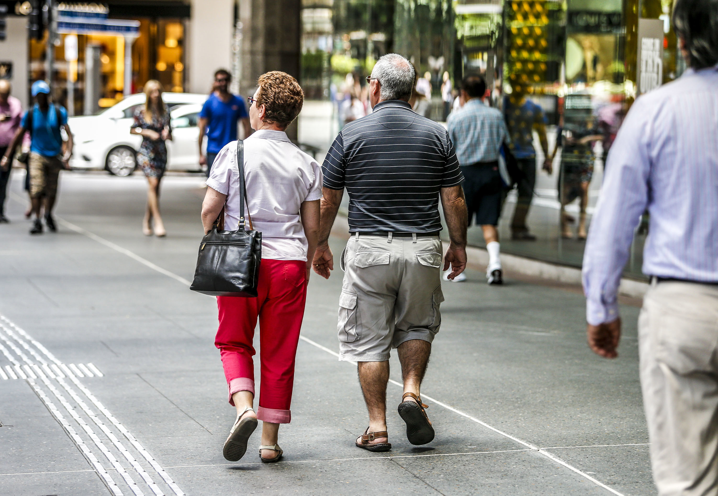 Two old people walk down the street in Brisbane