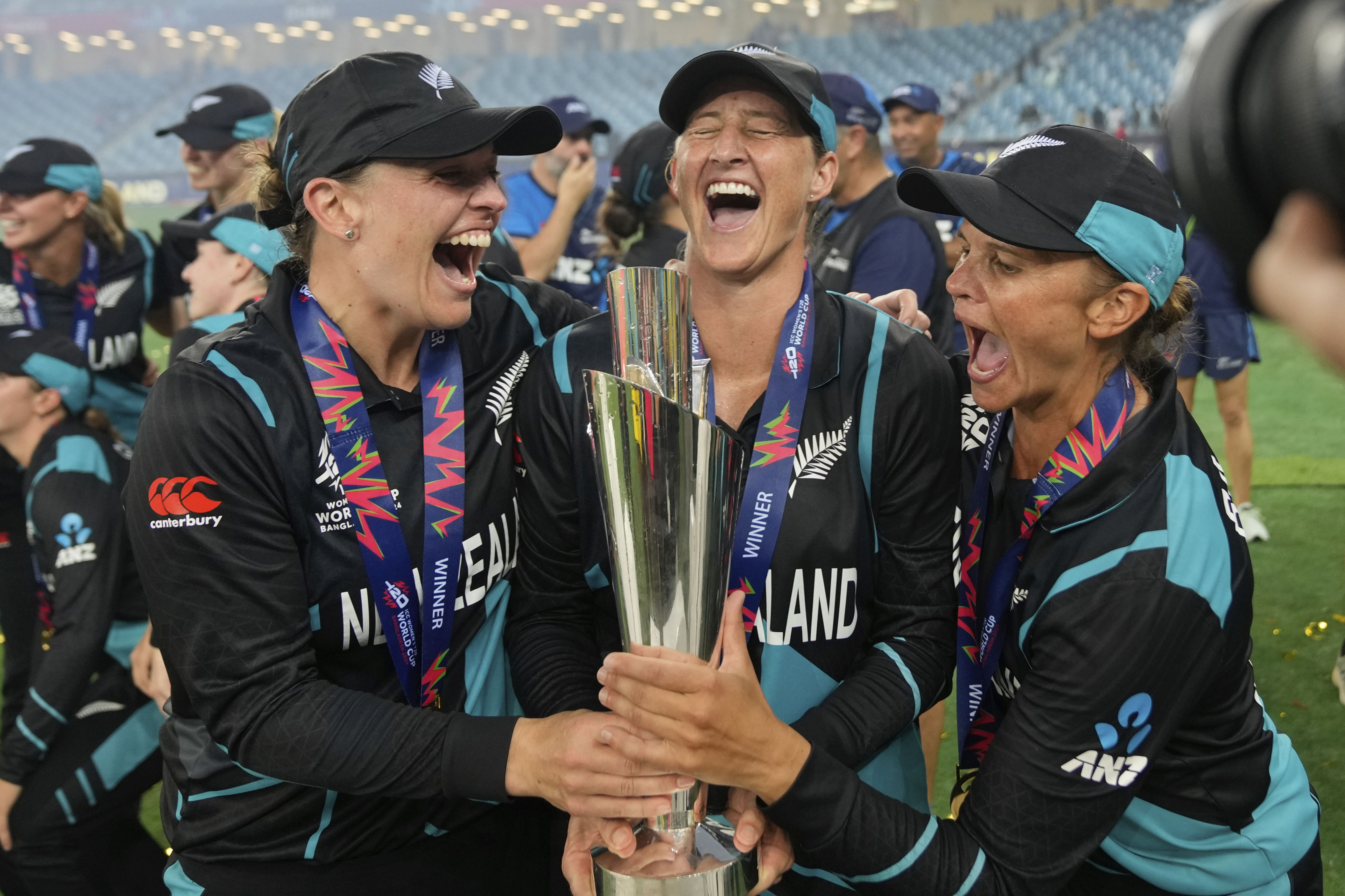 New Zealand's captain Sophie Devine, centre, poses with teammates Lea Tahuhu and Suzie Bates with the trophy after winning the ICC Women's T20 World Cup.