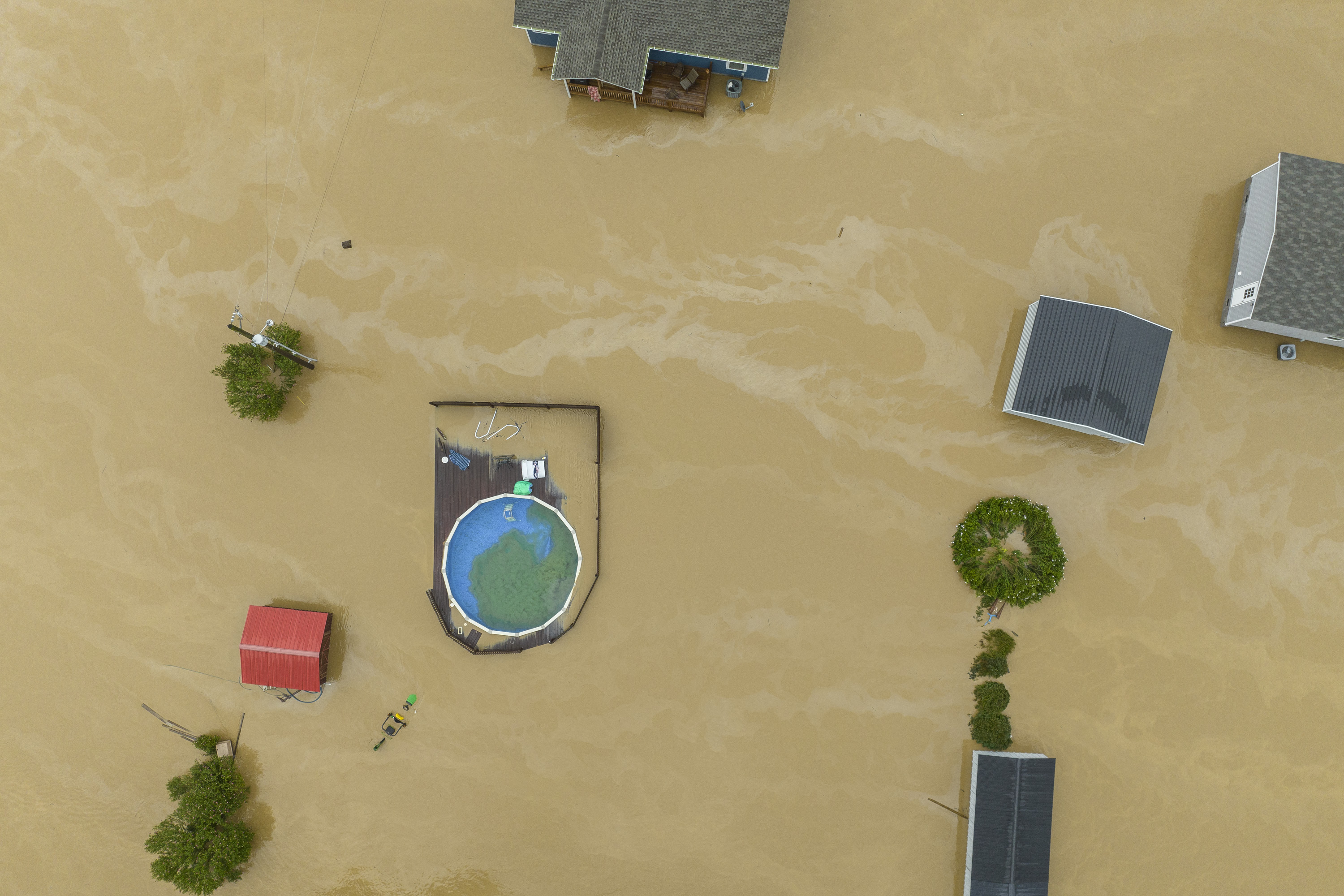 Home and structures are flooded near Quicksand, Ky., Thursday, July 28, 2022. Heavy rains have caused flash flooding and mudslides as storms pound parts of central Appalachia. Kentucky Gov. Andy Beshear says it's some of the worst flooding in state history. (Ryan C. Hermens/Lexington Herald-Leader via AP)