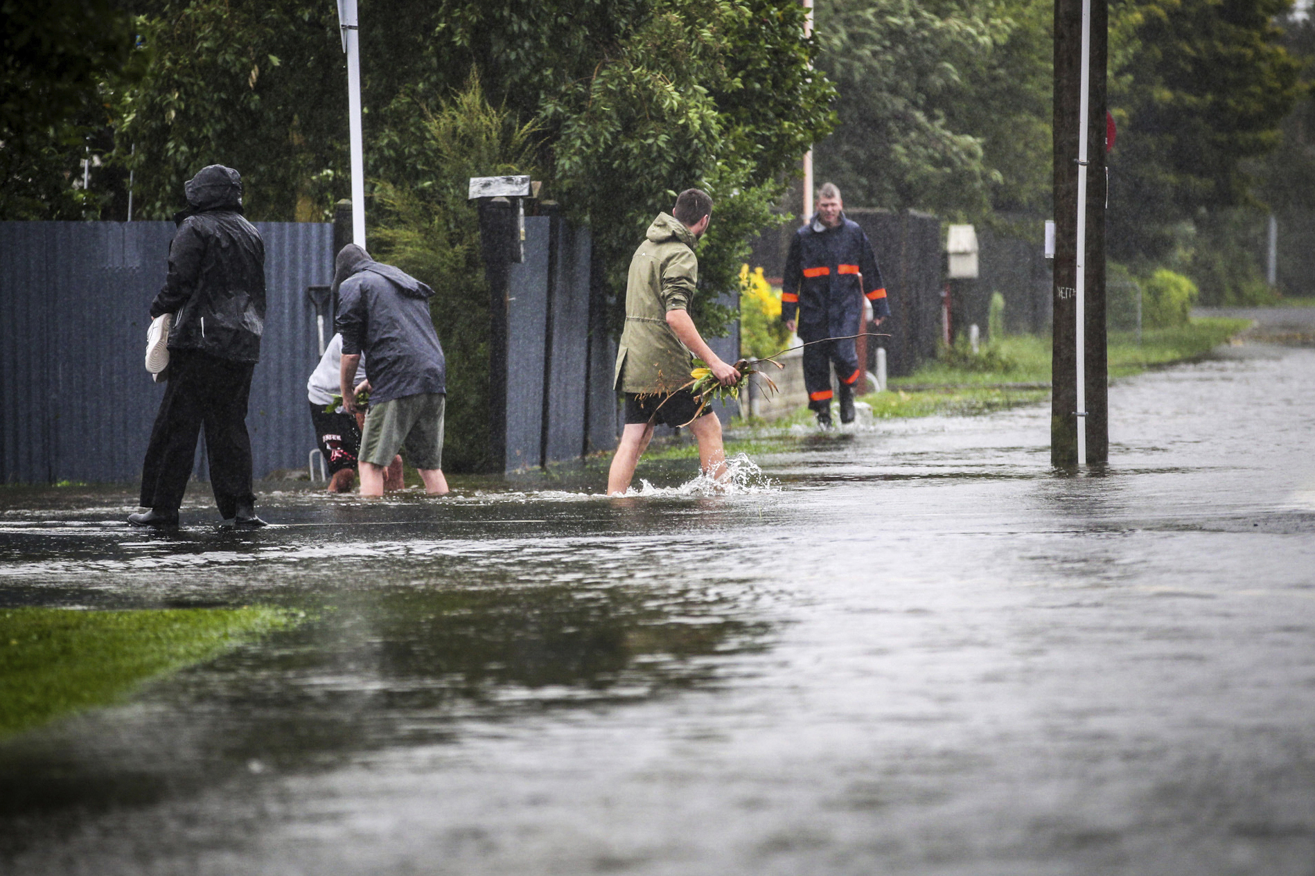 People walk through flood water in Hastings, southeast of Auckland, New Zealand, Tuesday, Feb. 14, 2023.