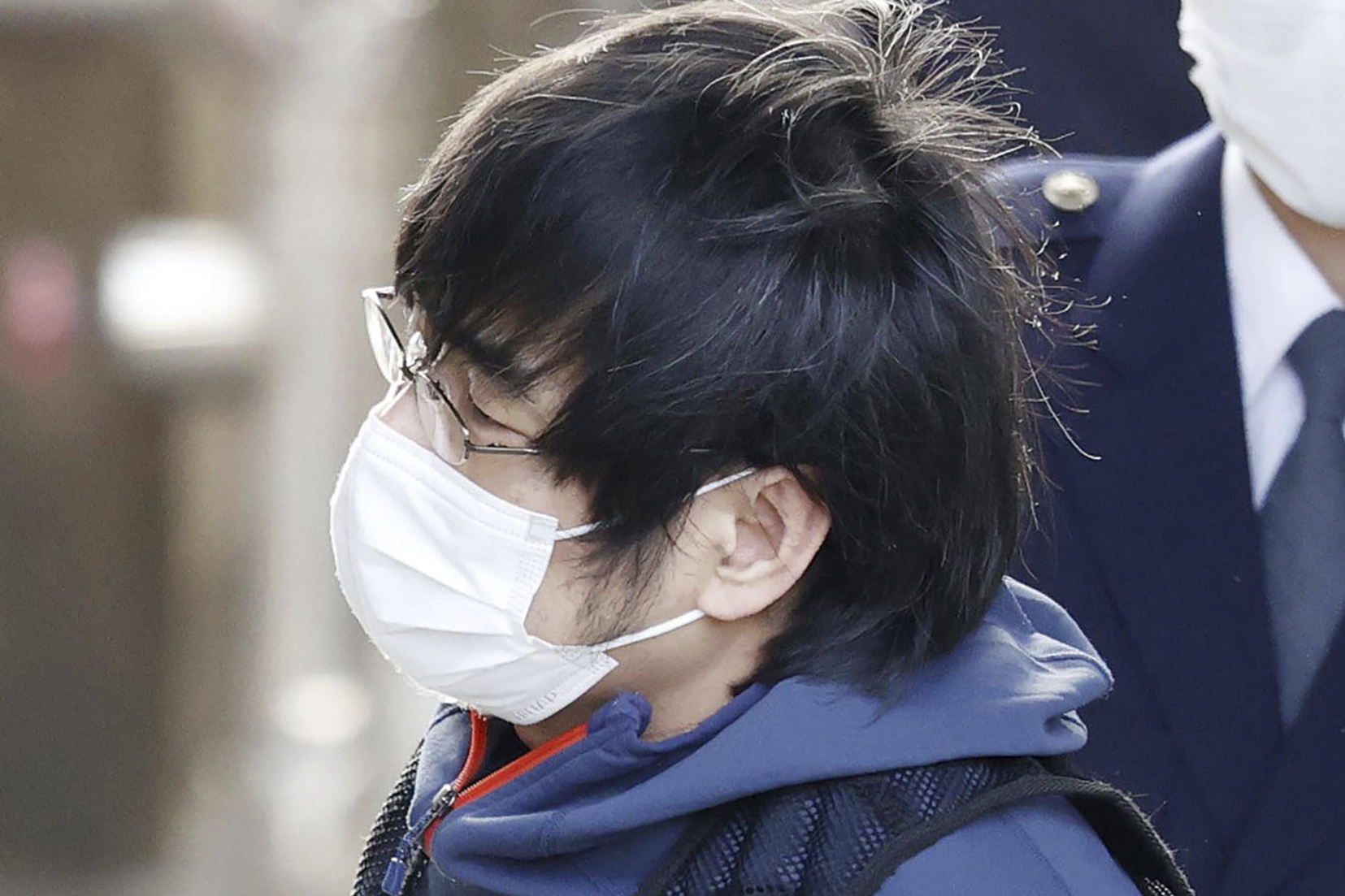 Tetsuya Yamagami, the alleged assassin of Japan's former Prime Minister Shinzo Abe, led by police officers, enters a police station in Nara, western Japan, on Jan. 10, 2023.  