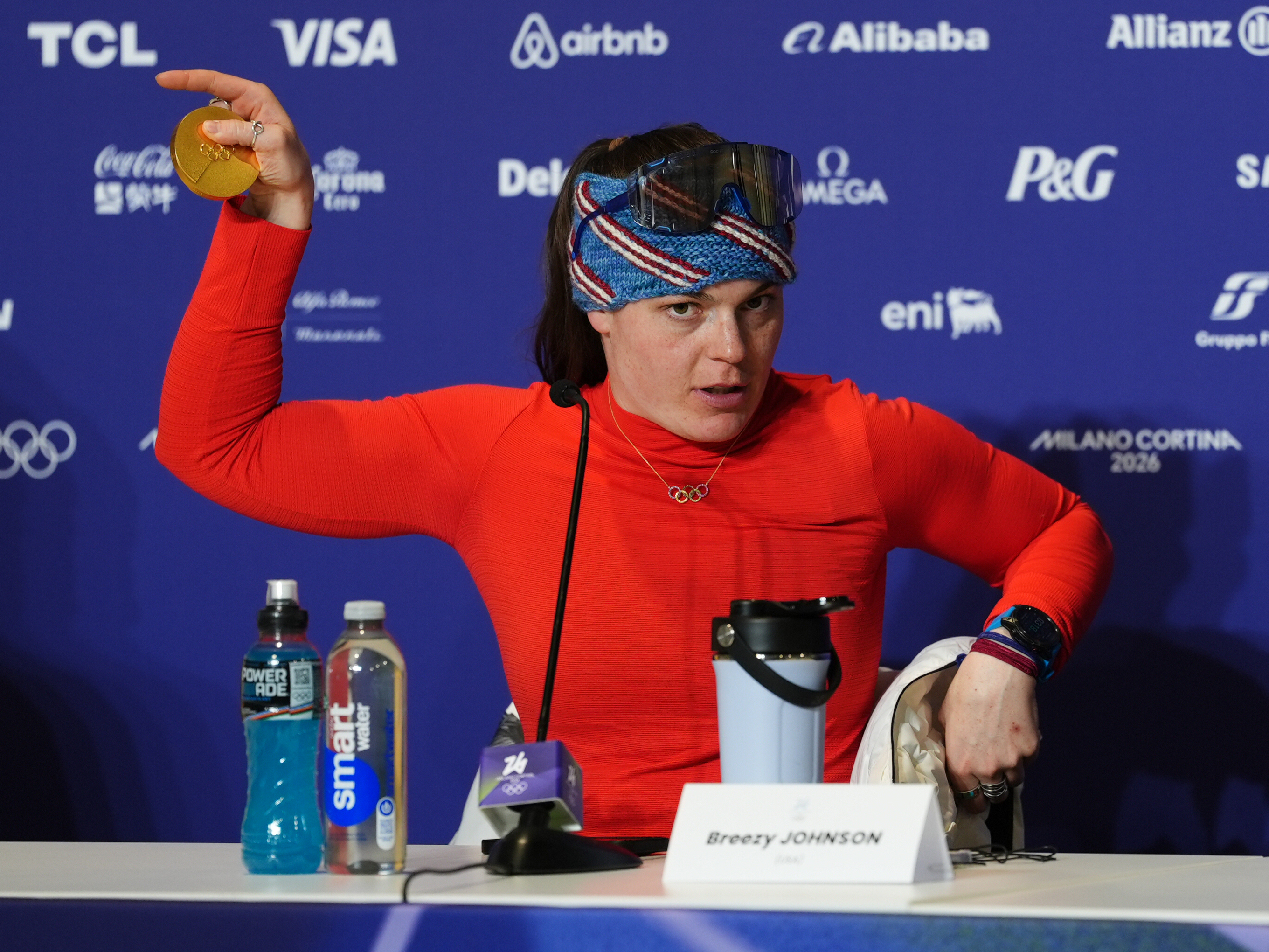 American gold medalist Breezy Johnson displays her broken medal to the media following her victory in the women's downhill.