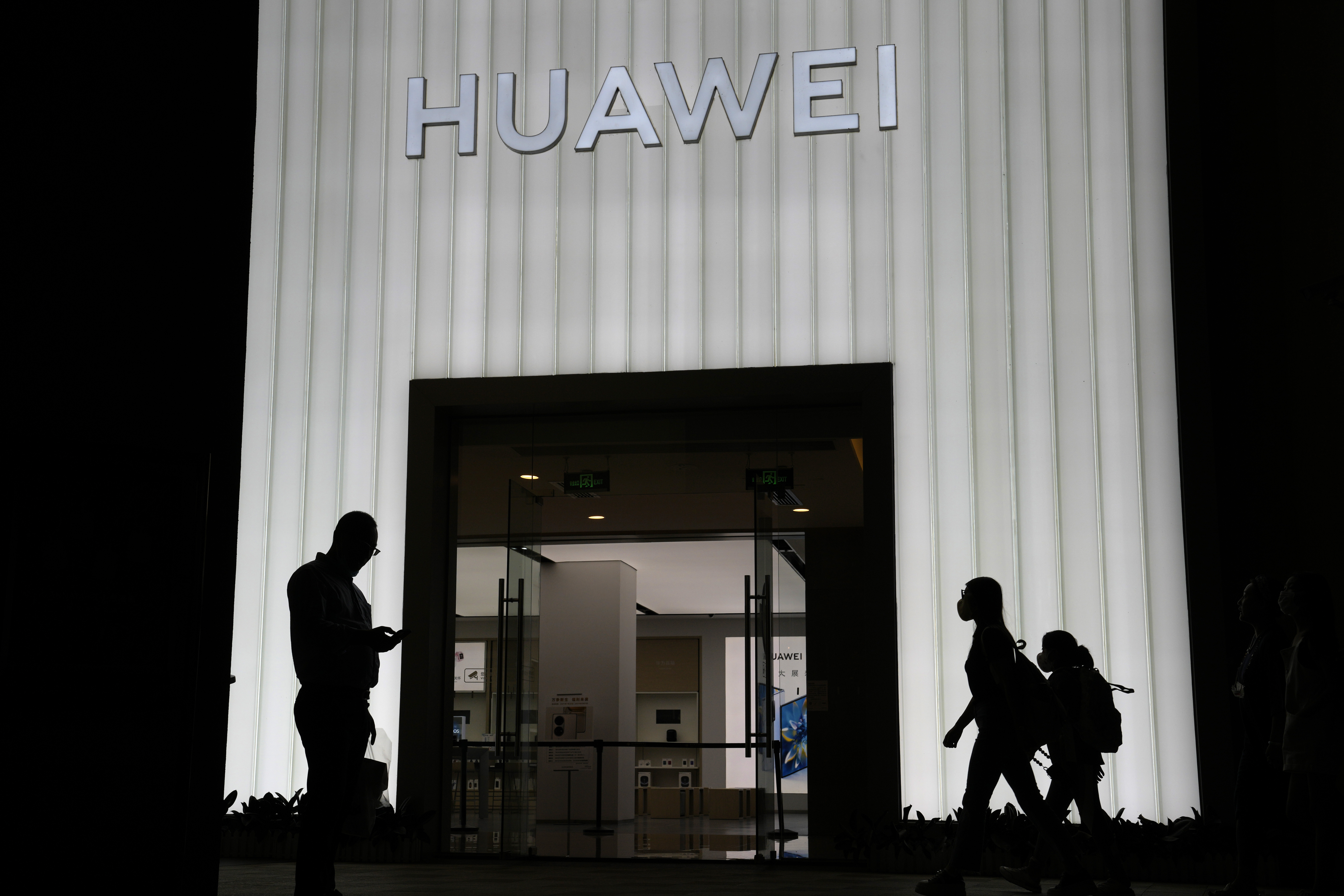 Los compradores pasan por una tienda Huawei en Beijing, China, el jueves 26 de agosto de 2021.  