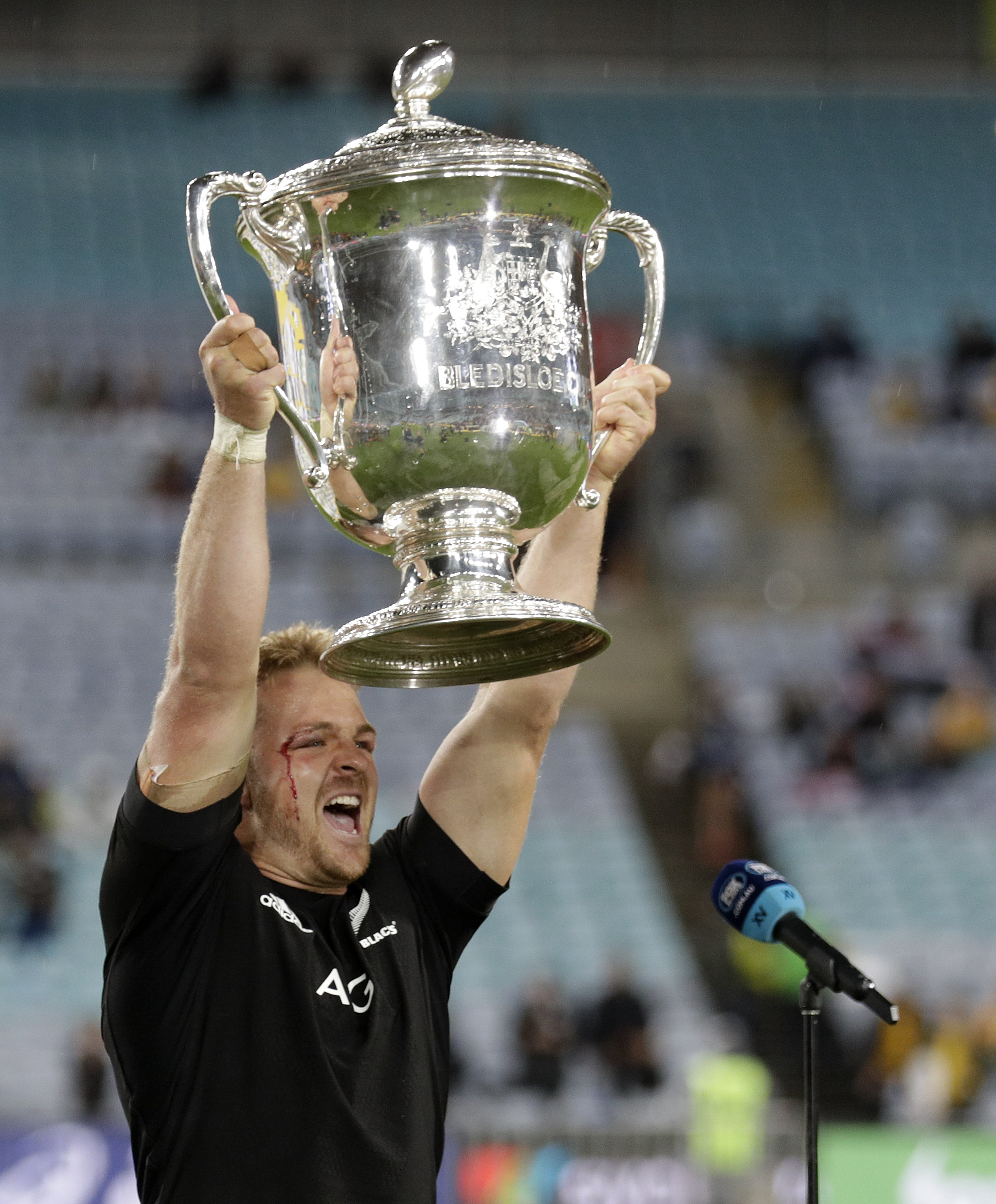 New Zealand captain Sam Cane holds the Bledisloe Cup aloft.