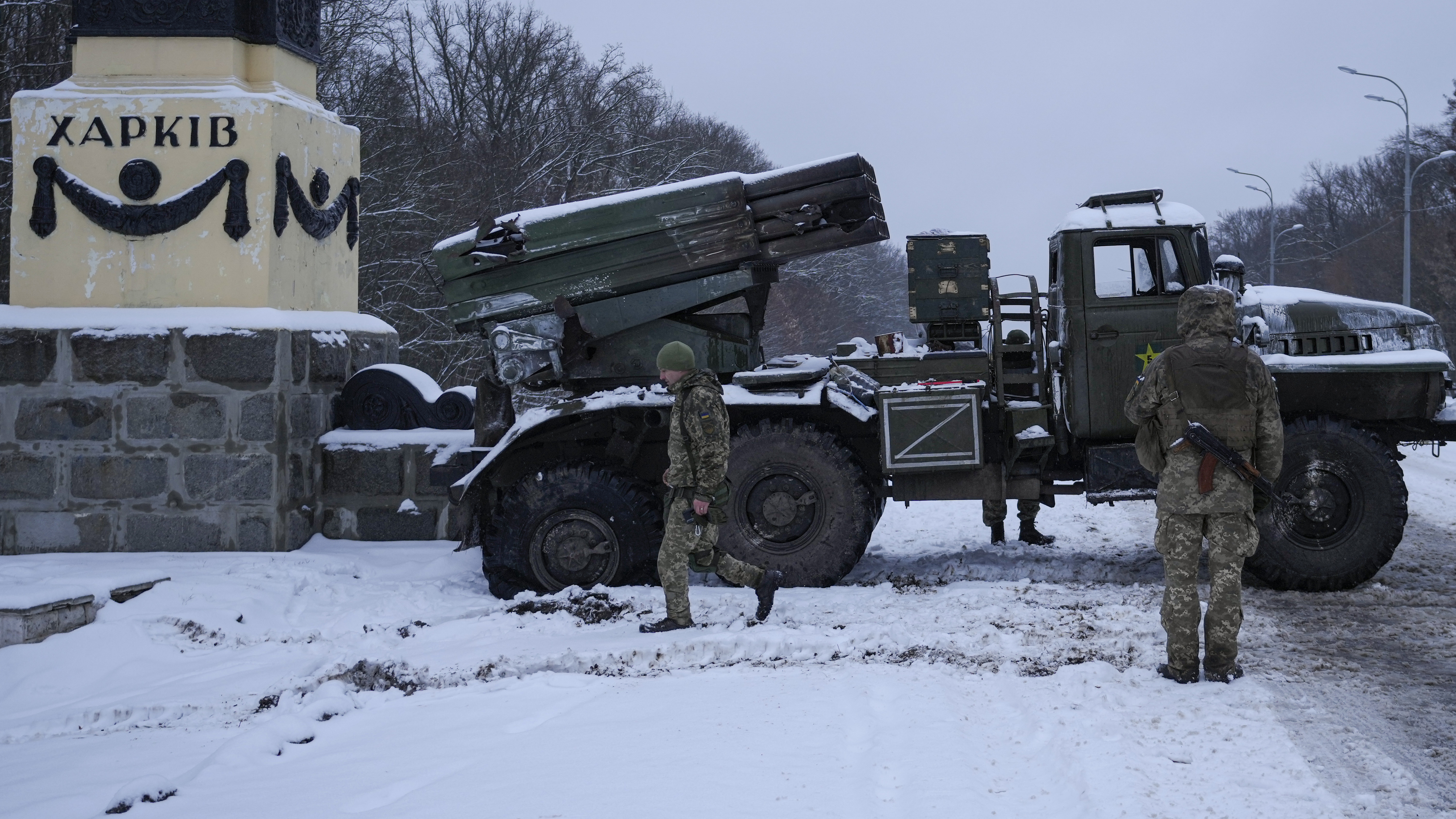 Ukrainian servicemen walk by a deactivated Russian military multiple rocket launcher on the outskirts of Kharkiv, Ukraine.