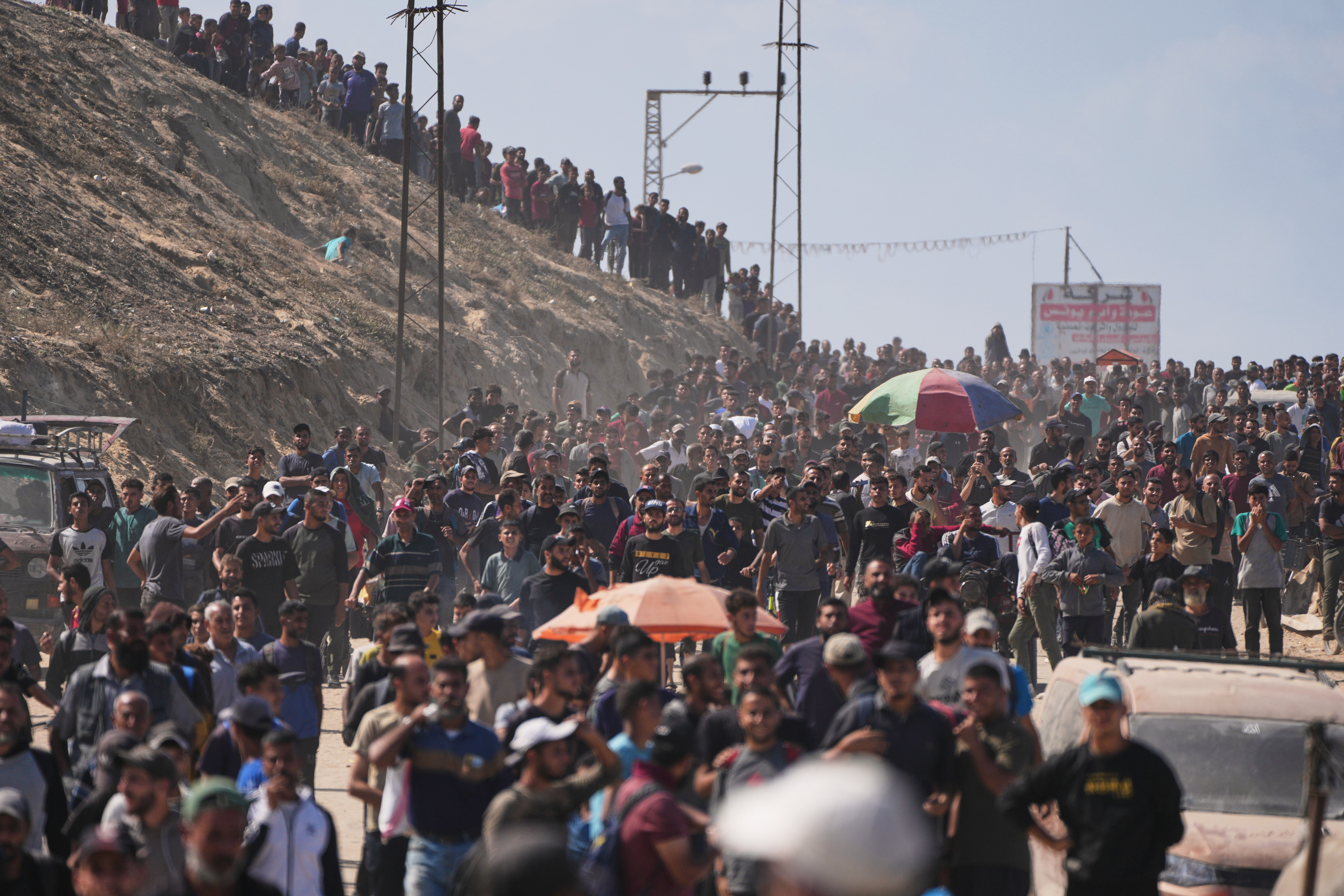 Displaced Palestinians walk along the coastal road near Wadi Gaza in the central Gaza Strip