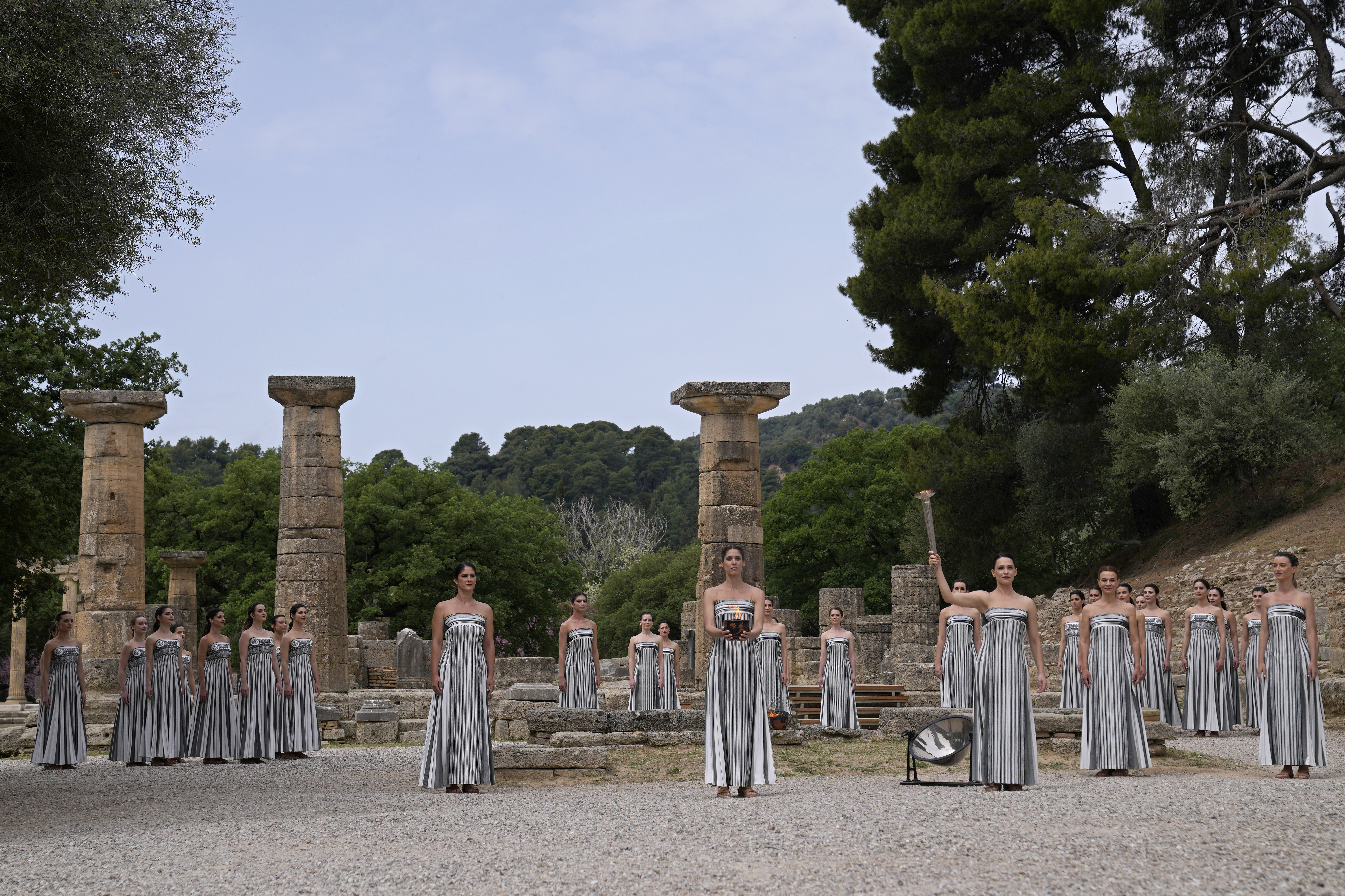 Actress Mary Mina, playing high priestess, right, holds a torch with the flame during the official ceremony of the flame lighting for the Paris Olympics