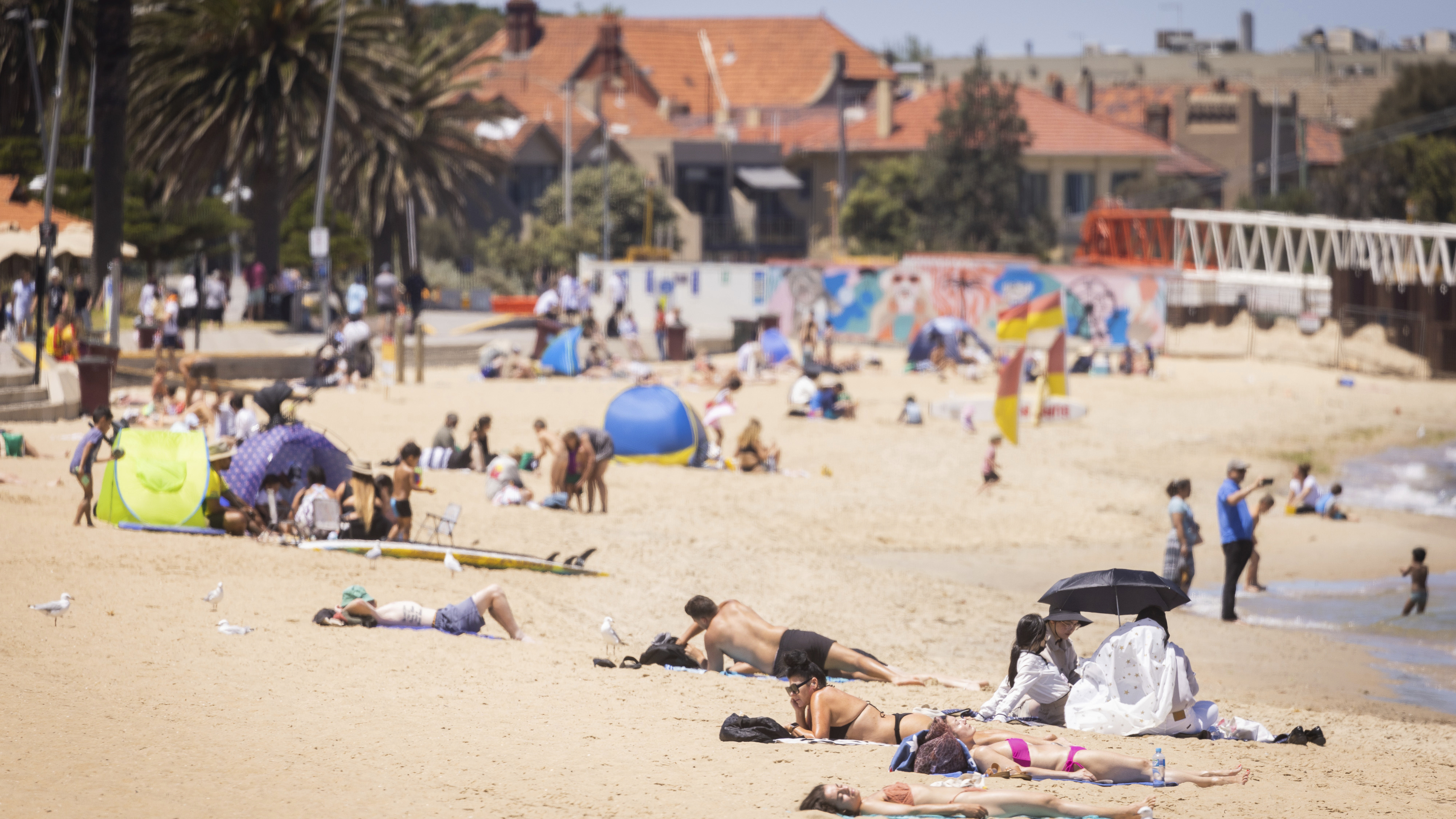 People enjoying the warm weather on St Kilda Beach, Melbourne.