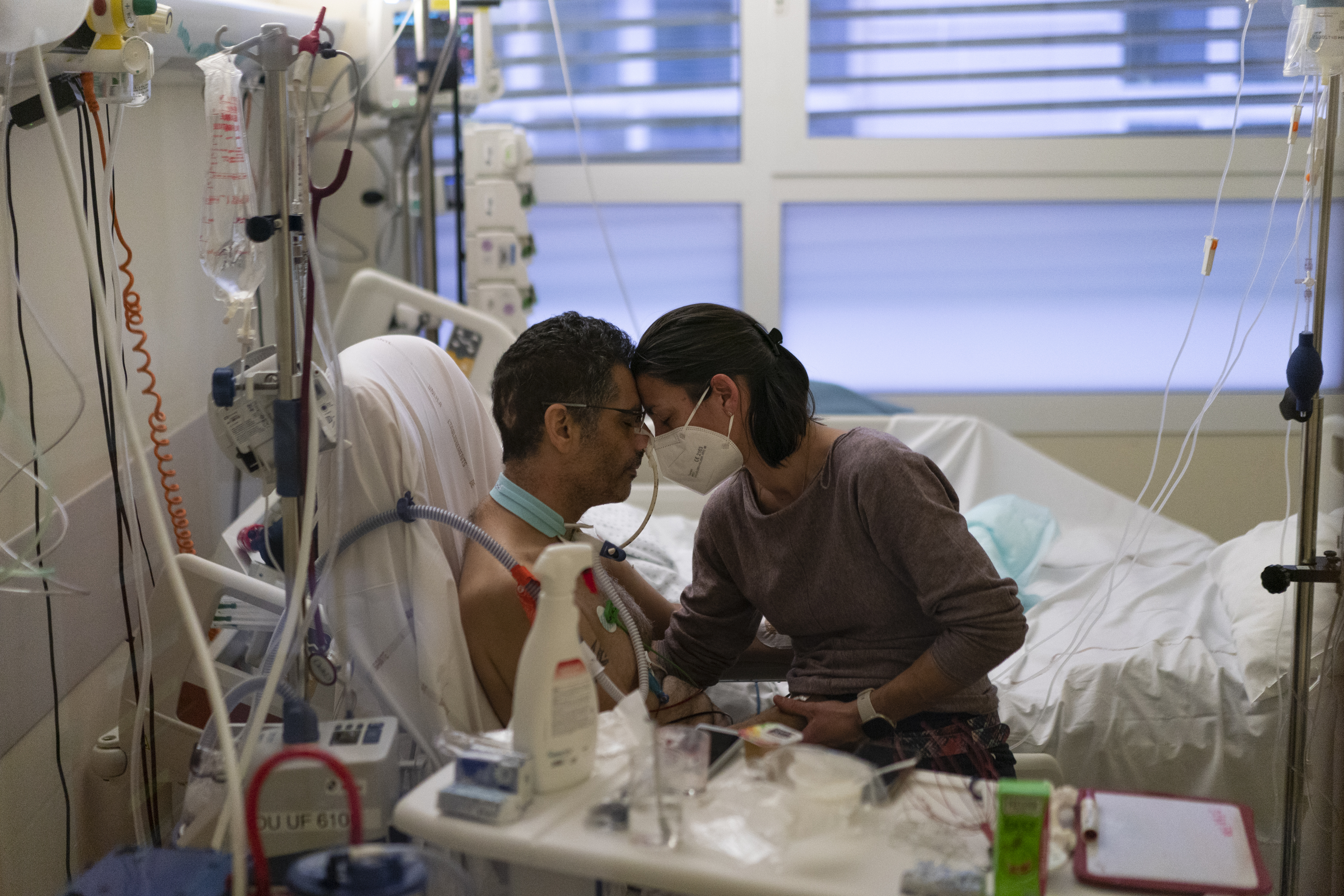 Amelie and Ludo Khayat hold each other during a visit at the COVID-19 intensive care unit of the la Timone hospital in Marseille, southern France, Thursday, Dec. 23, 2021.