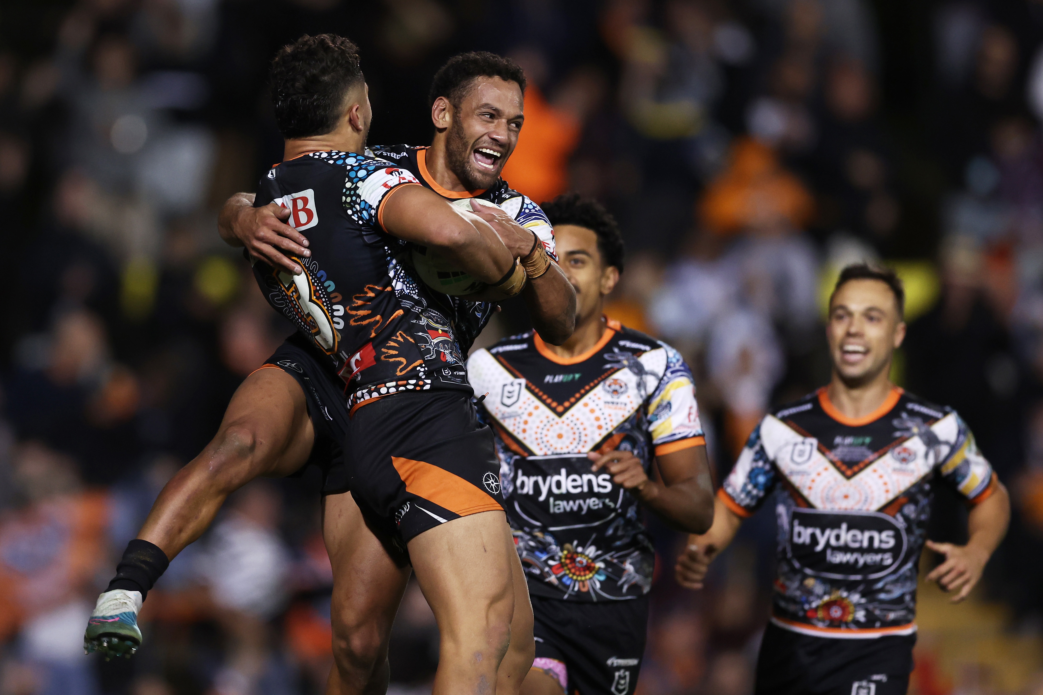 Starford To'a celebrates with Apisai Koroisau after scoring a try during the round 12 NRL match between Wests Tigers and North Queensland Cowboys.