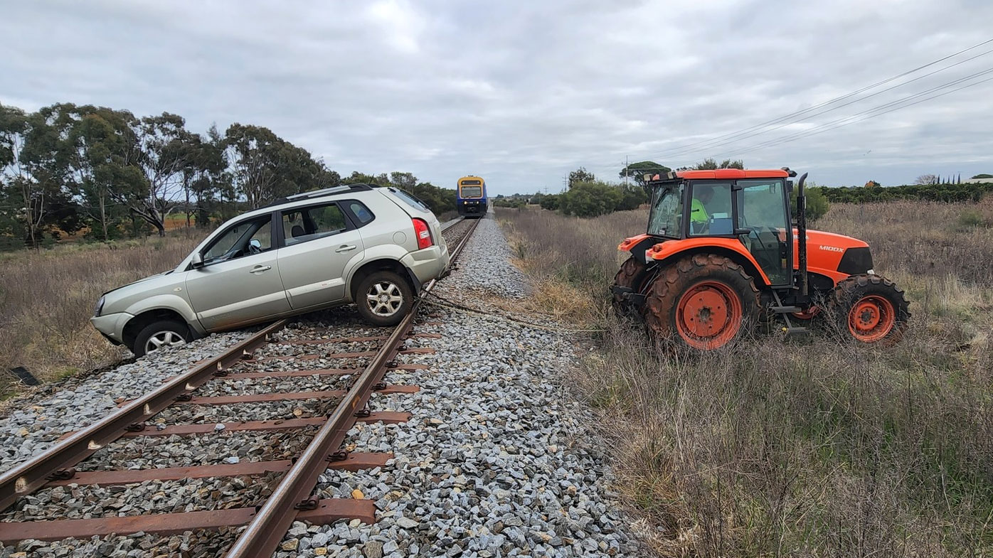 A local farmer used his tractor to pull the car off the train tracks.