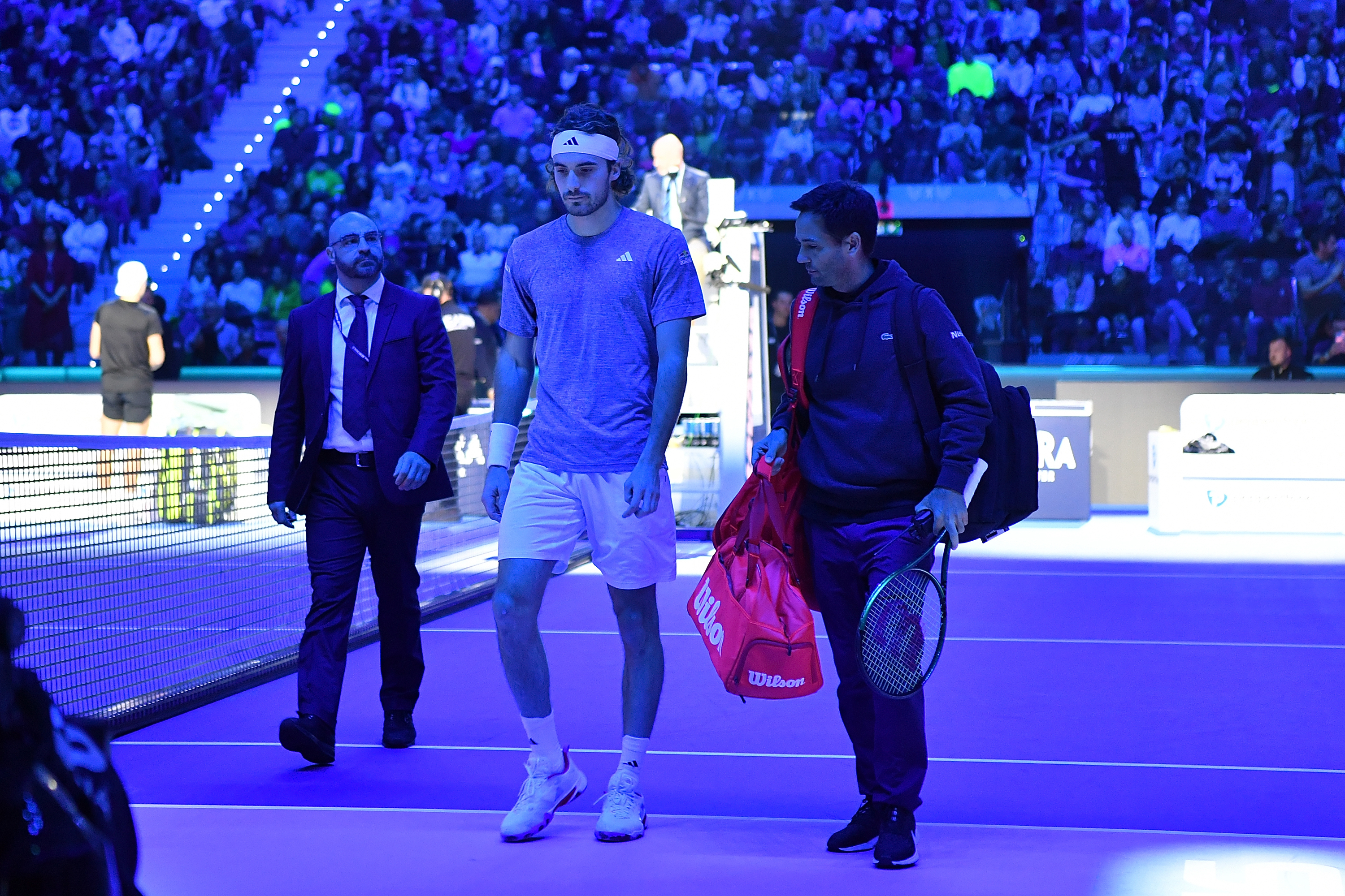Stefanos Tsitsipas looks dejected after retiring from his round-robin match against Holger Rune at the ATP Finals.