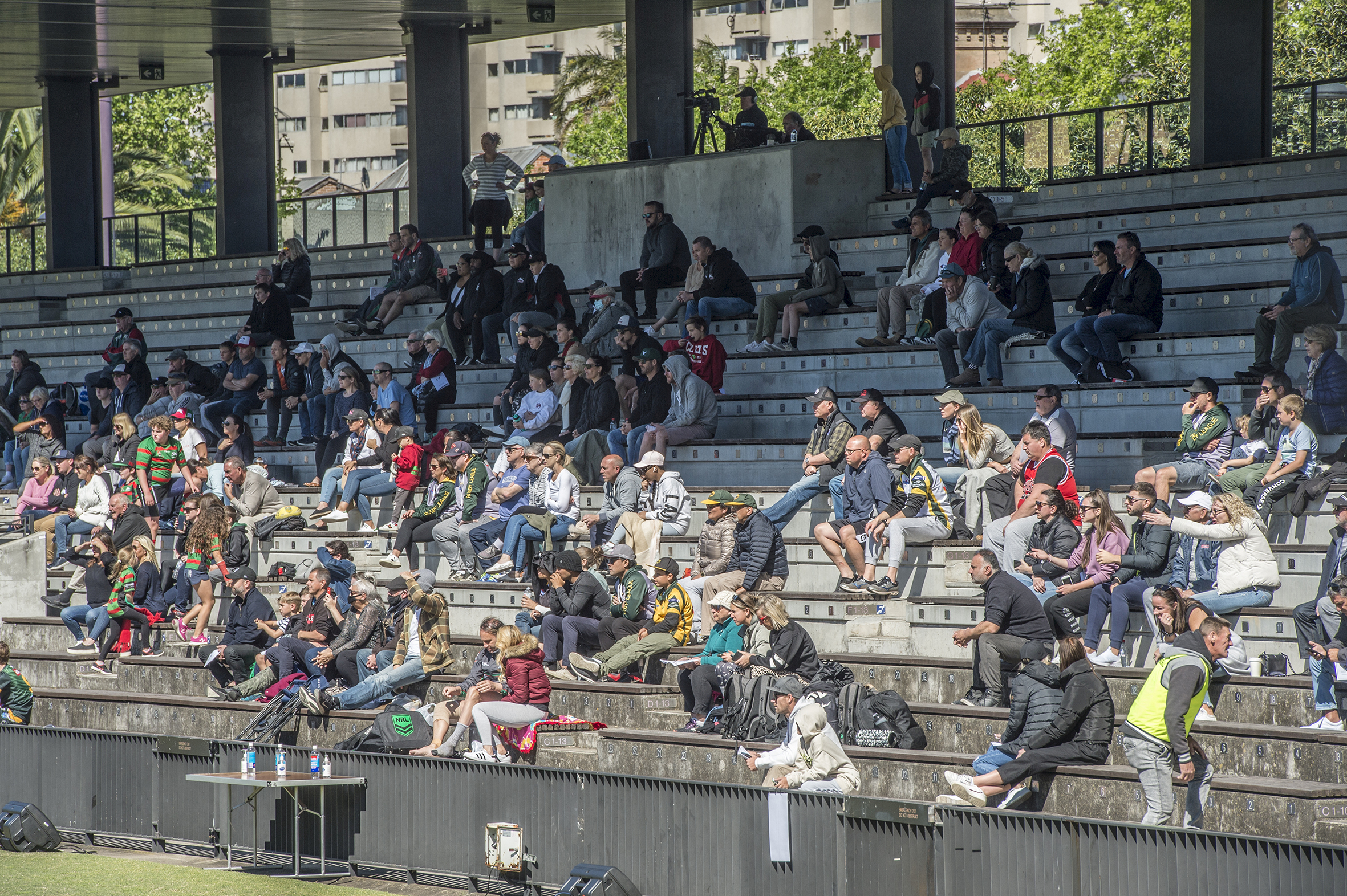 A crowd watches a junior rugby league game.