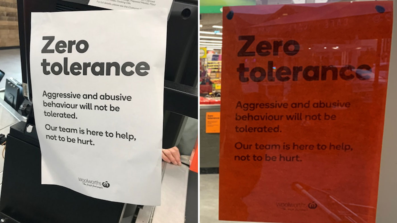 Signs in Woolworths stores urging customers not to abuse staff.