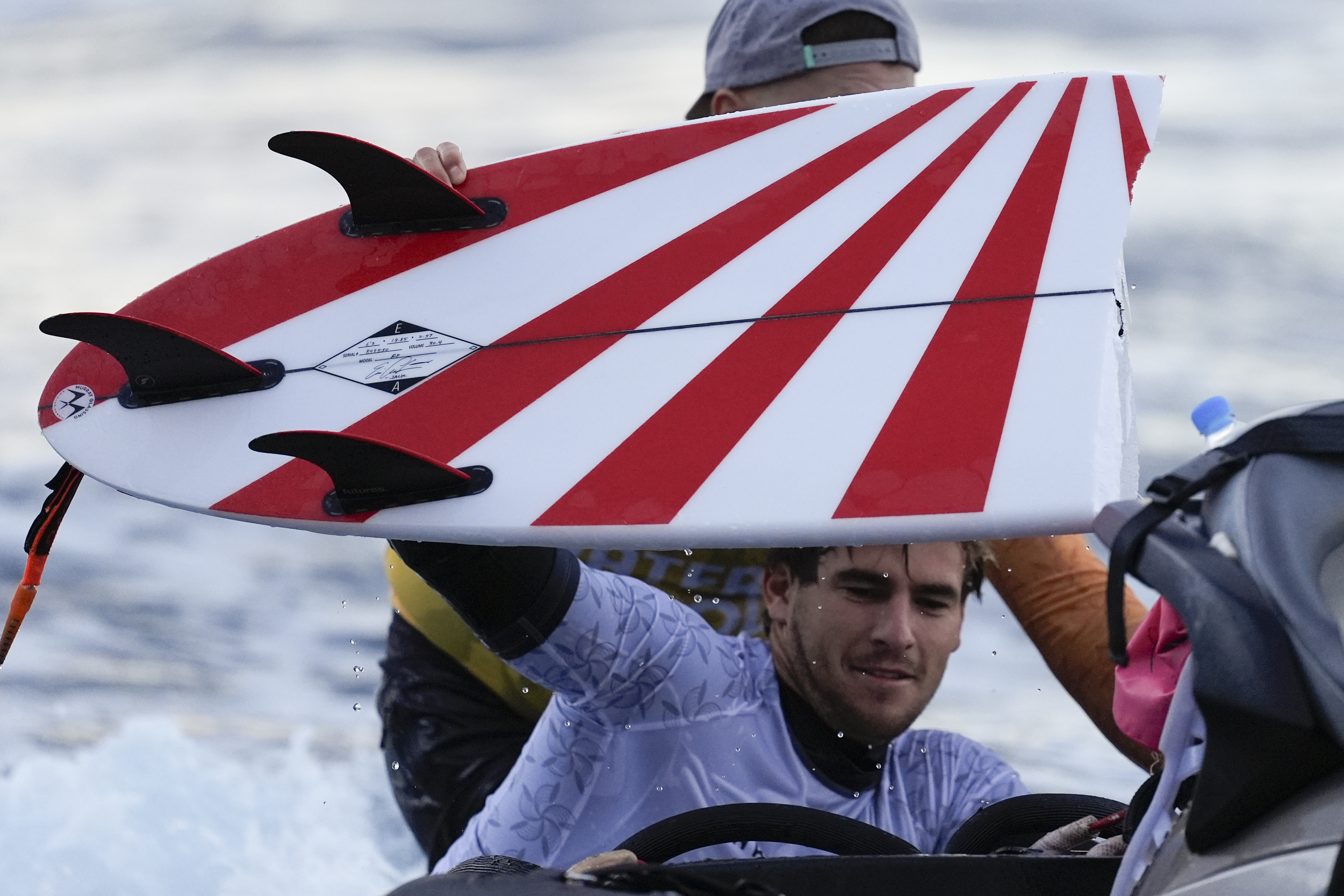 Australia's Jack Robinson rides on the back of a jet ski after breaking his board during a training session.