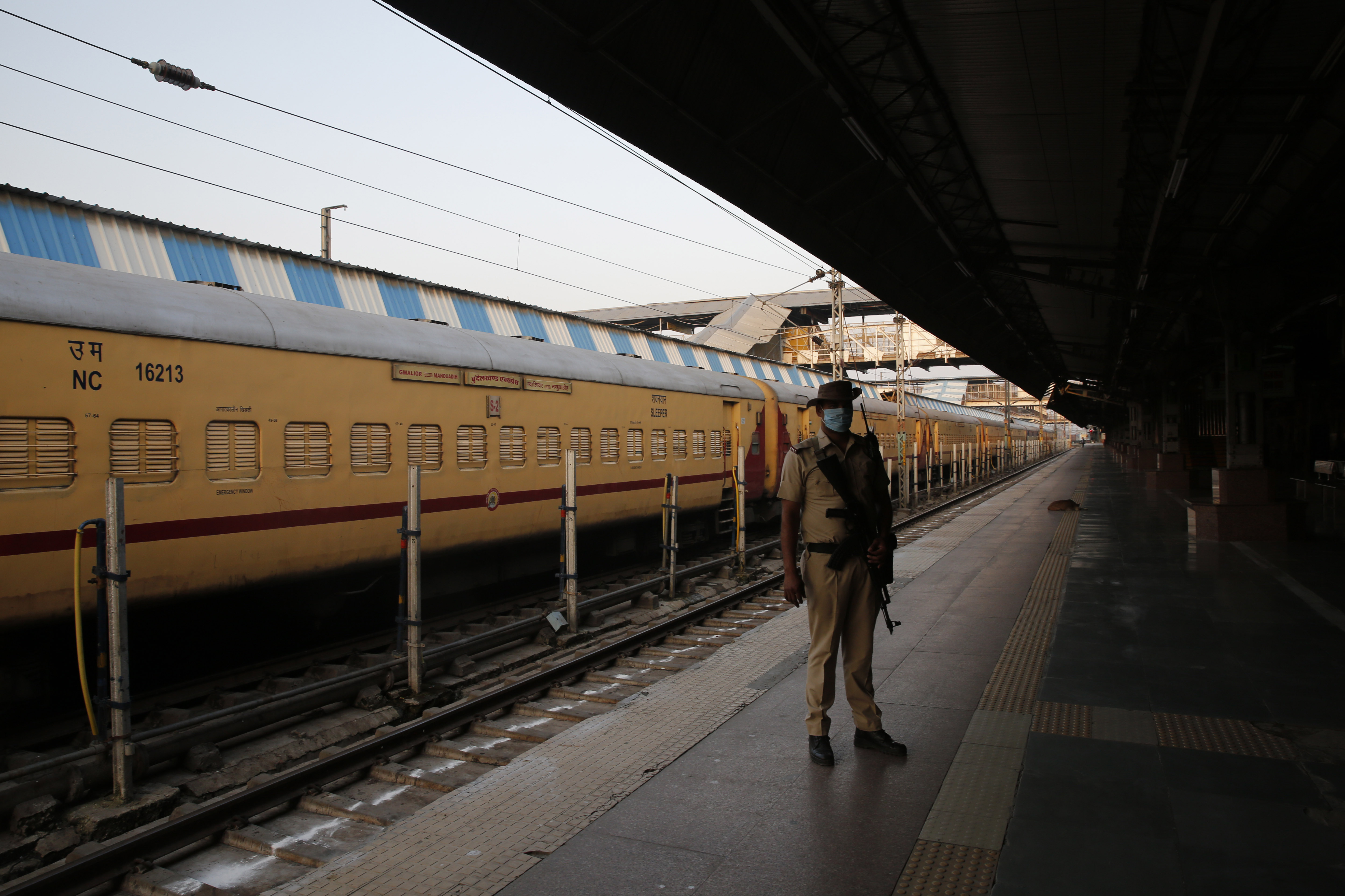 A security man stands guard at a deserted railway station in Prayagraj, India.