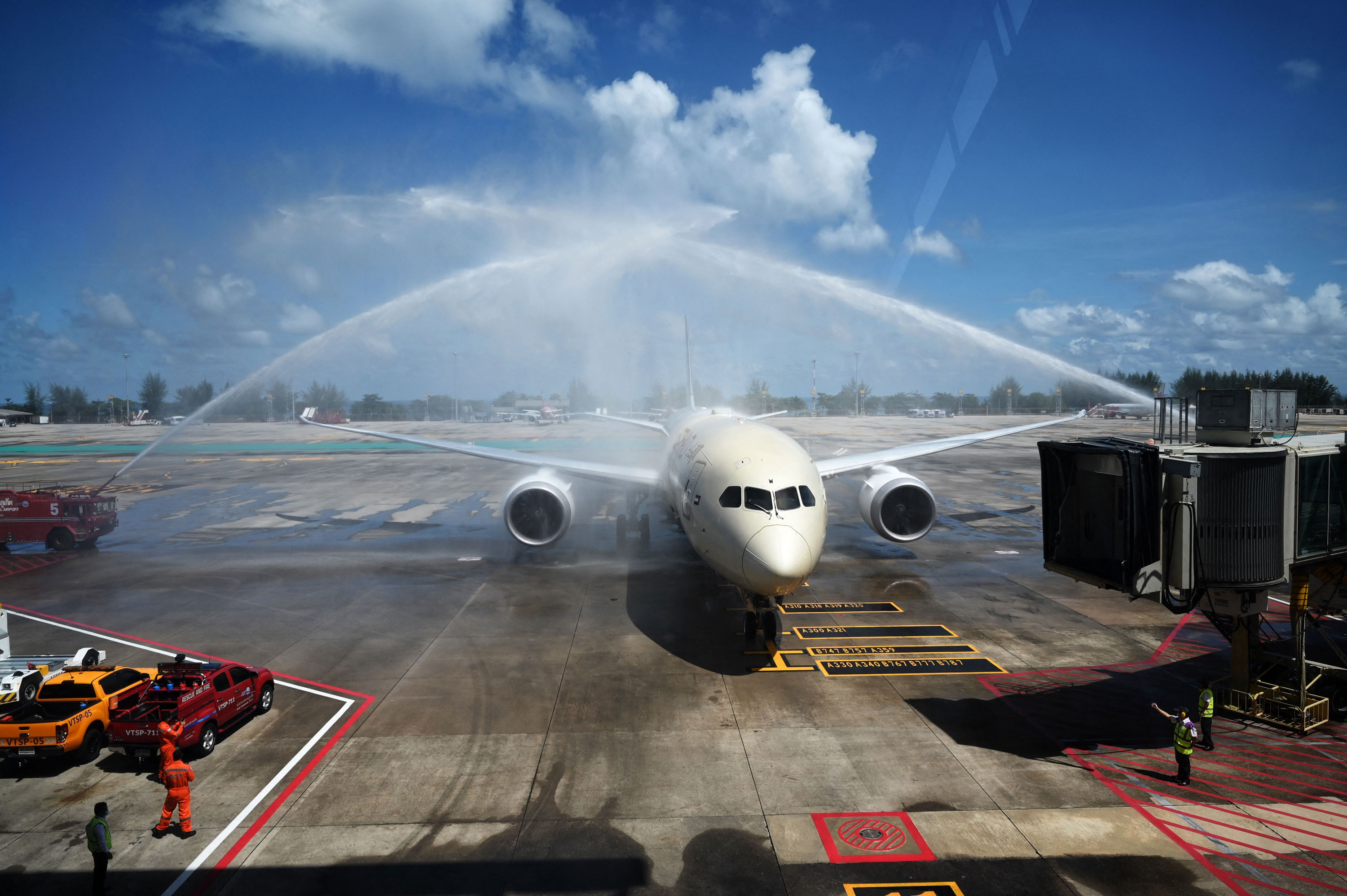 Celebratory sprays of water are splashed over an Etihad Airways airplane arriving from Abu Dhabi carrying passengers for the Phuket Sandbox tourism scheme. (Photo by Lillian SUWANRUMPHA / AFP) (Photo by LILLIAN SUWANRUMPHA/AFP via Getty Images)