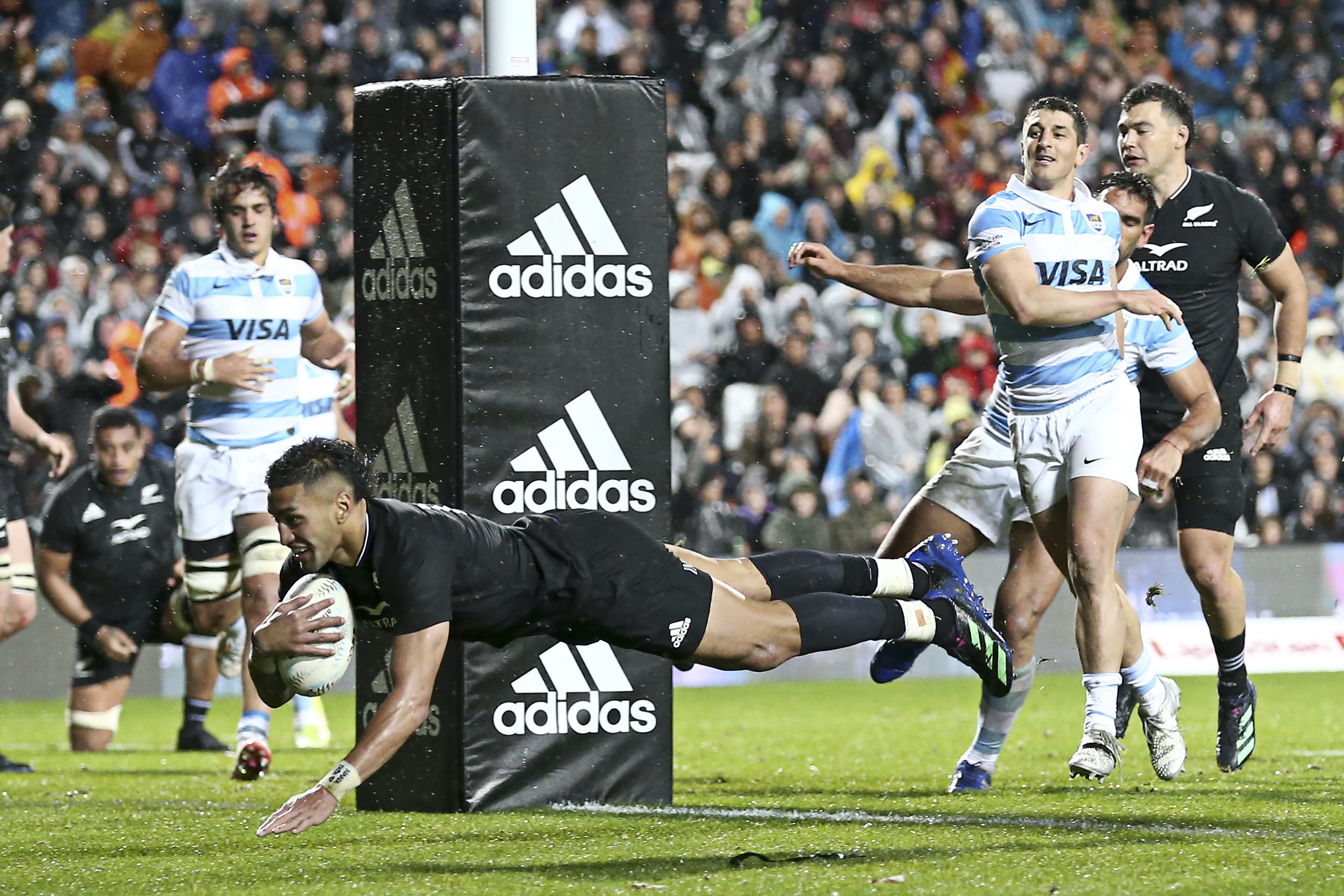 New Zealand's Rieko Ioane dives across the line to score a try.